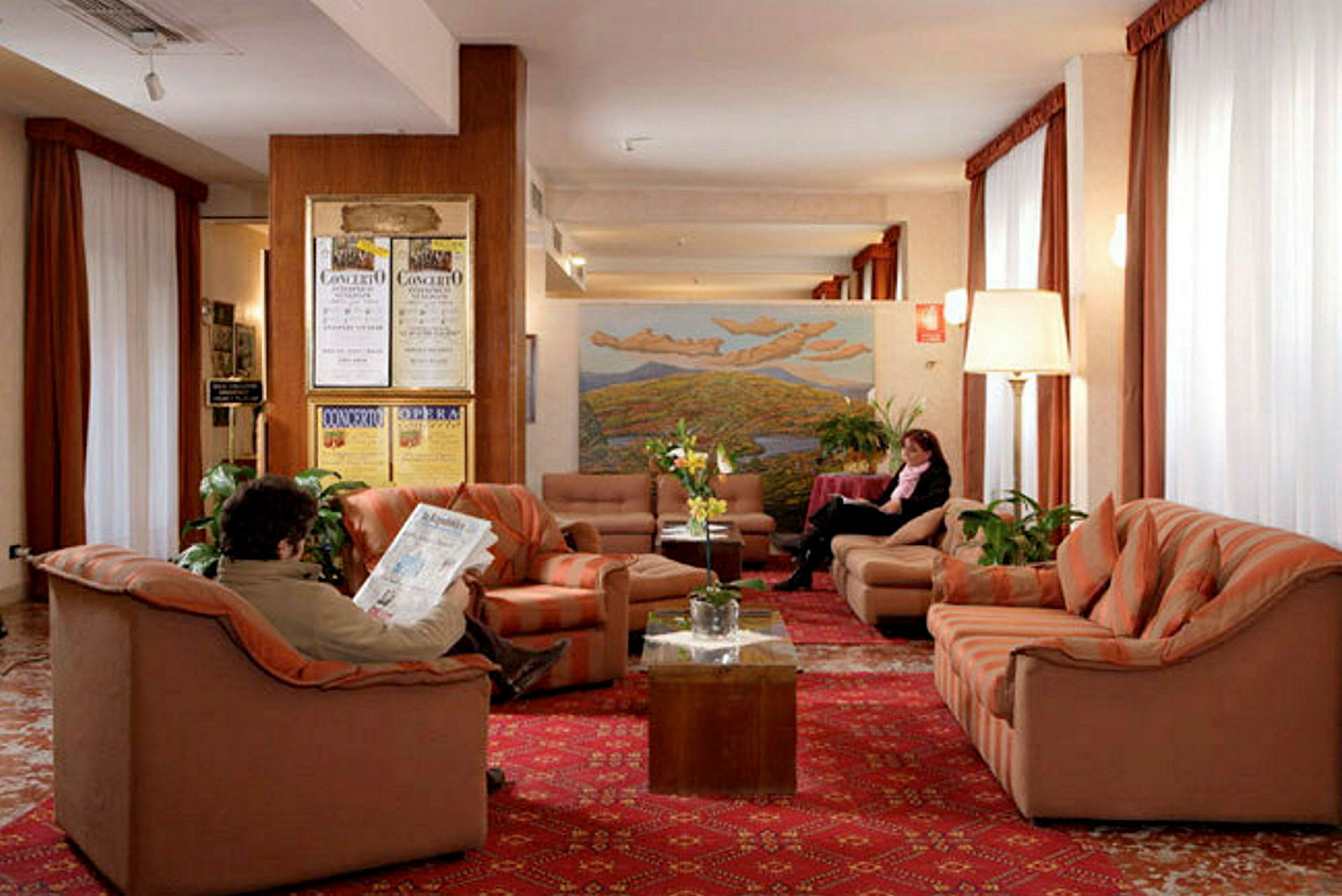 Bild av en hotelllobby med soffor och fåtöljer placerade på en röd matta. (AI-genererad text)