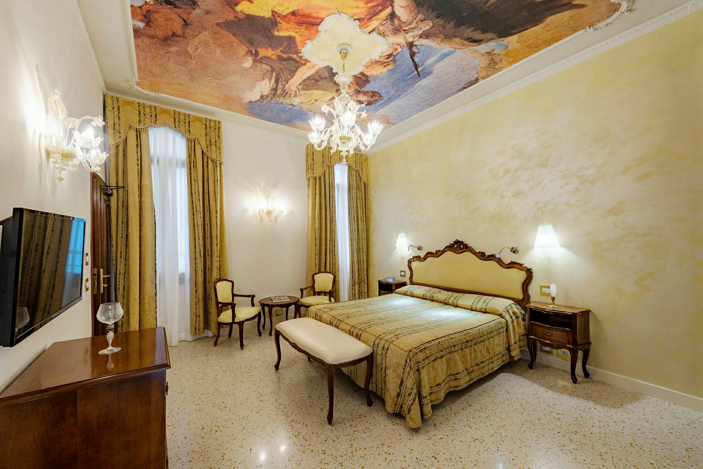 Ett elegant hotellrum med målningar i taket och ljuskrona. (AI-genererad text)