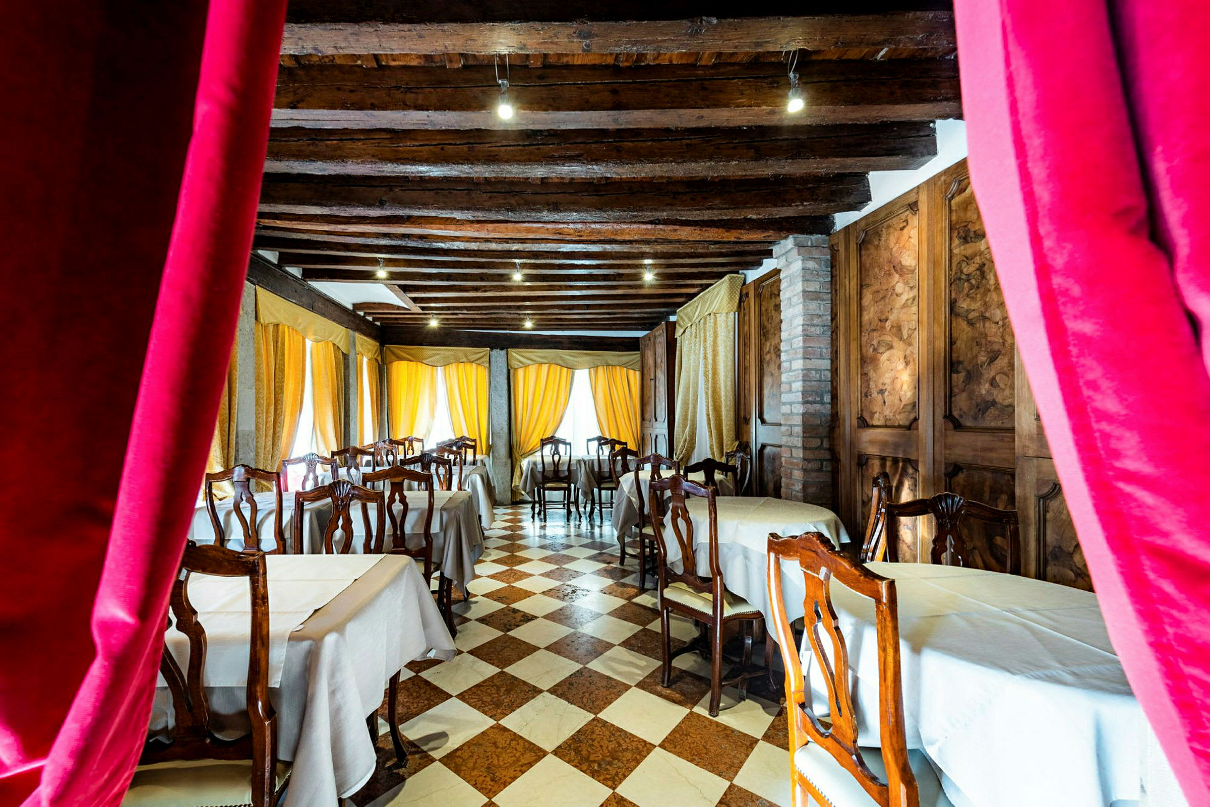 Interiör av restaurang med dukade bord och trästolar. (AI-genererad text)