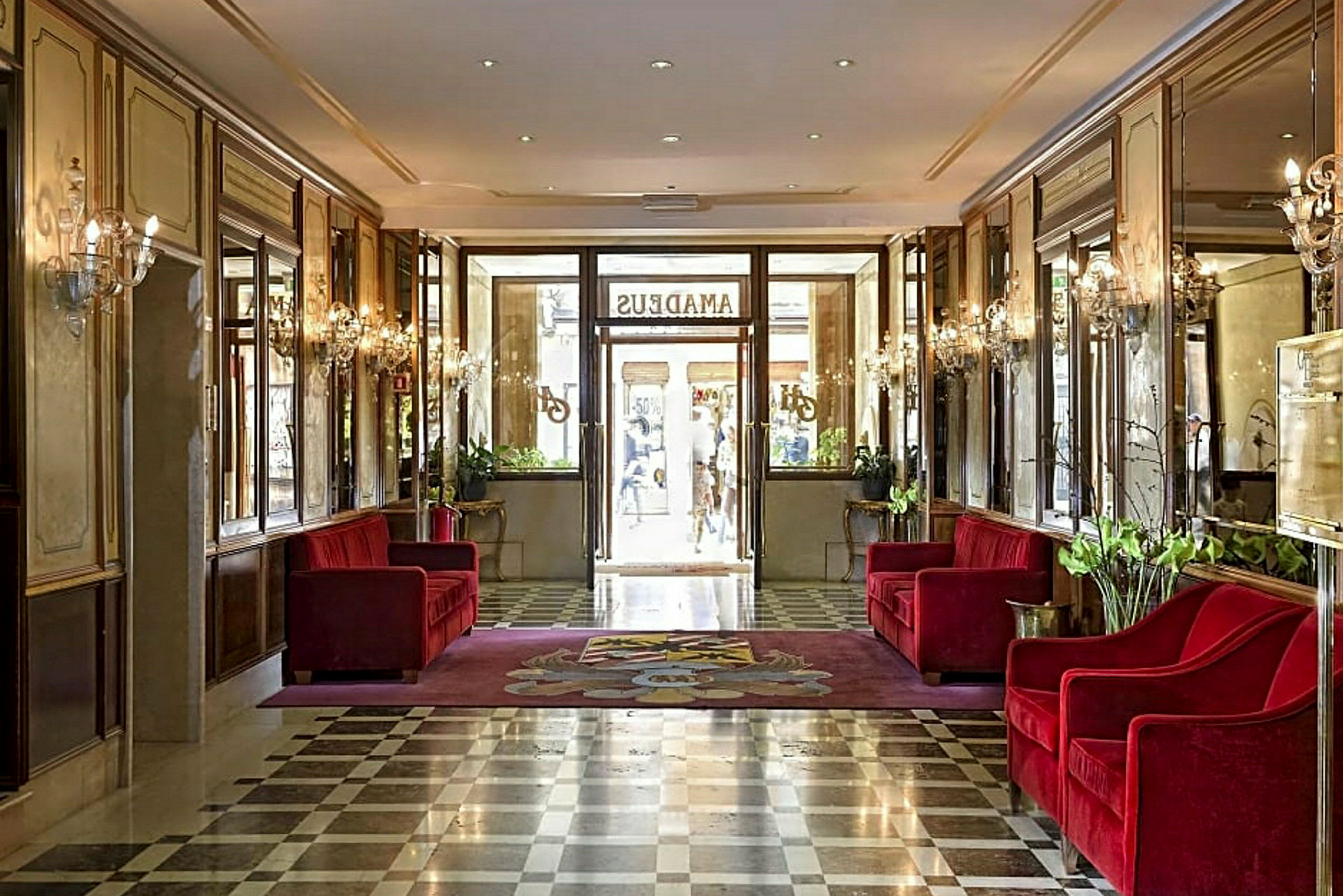 Hotellobby med röda soffor och marmorgolv. (AI-genererad text)