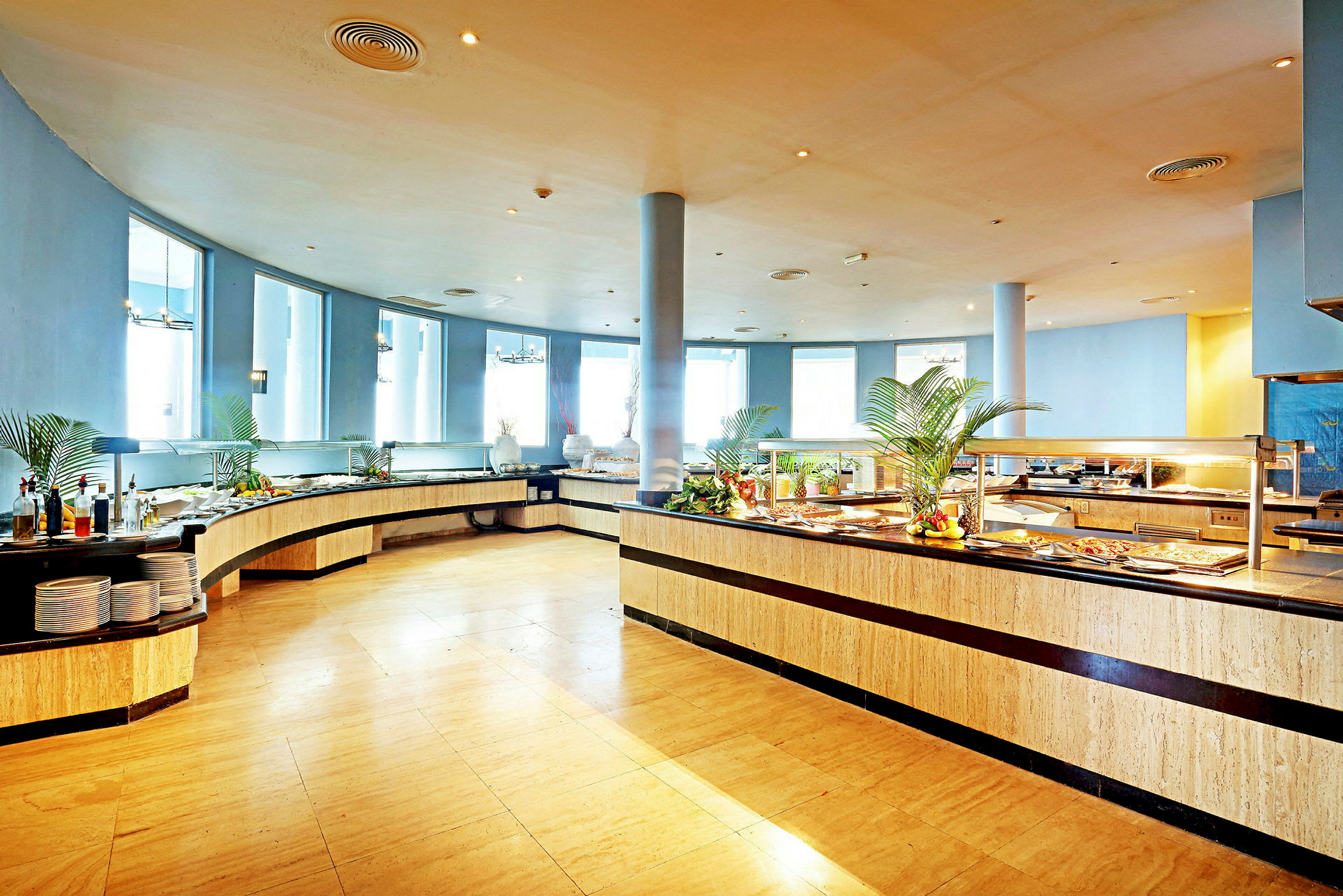 En ljus och rymlig bufférestaurang med mat upplagd på långa serveringsbord. (AI-genererad text)