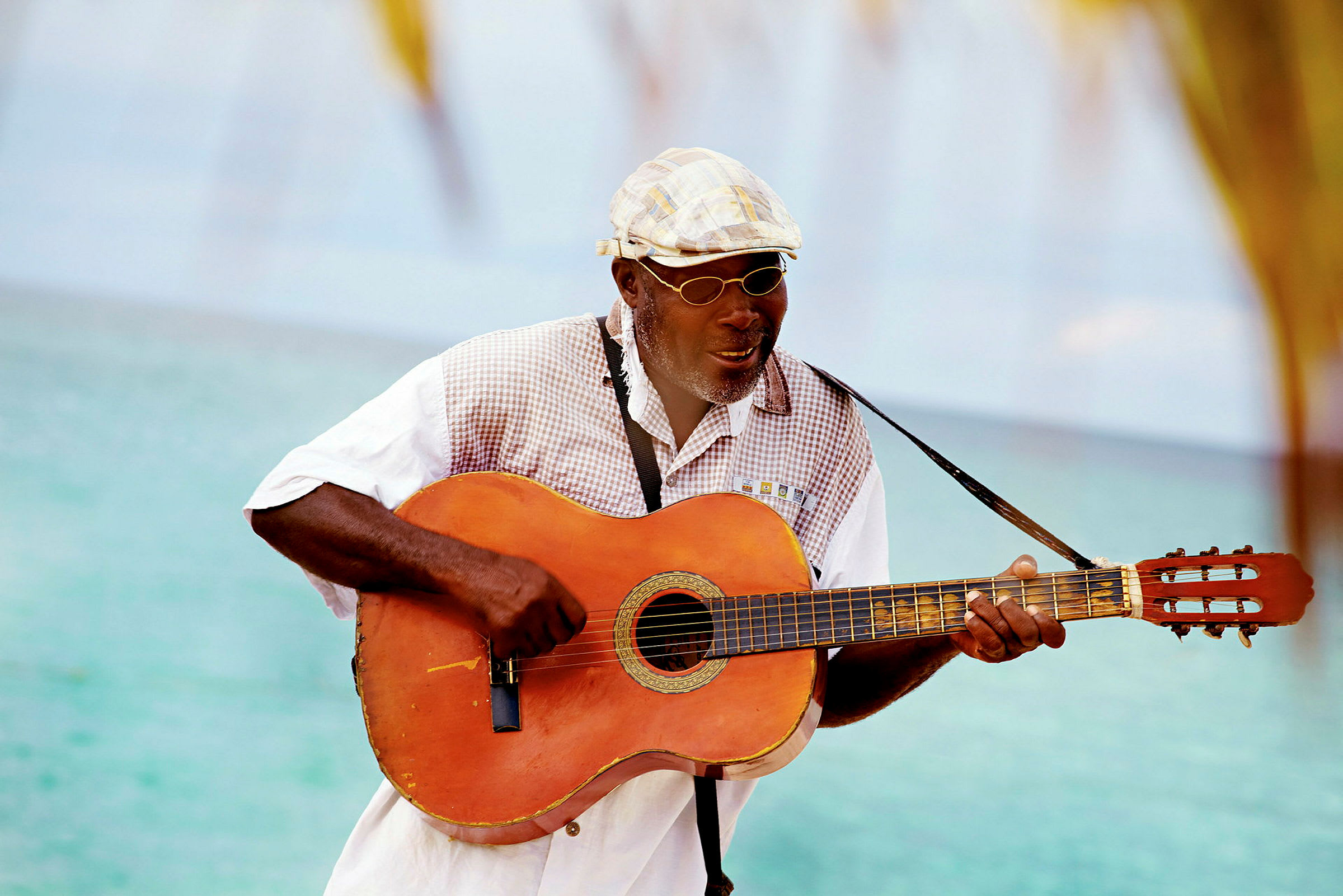 En person spelar gitarr vid havet. (AI-genererad text)