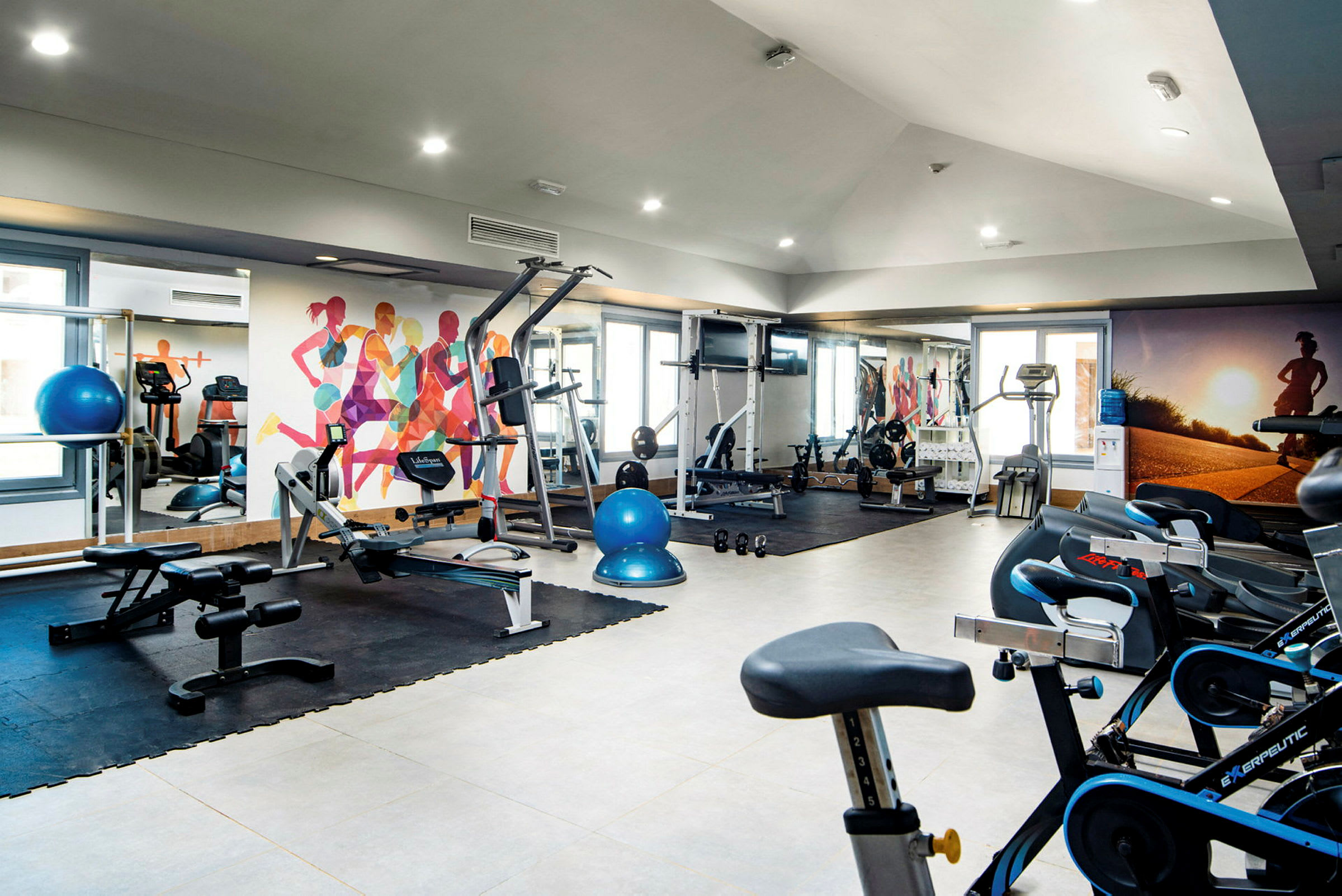 Ett gym med olika träningsmaskiner och utrustning. (AI-genererad text)