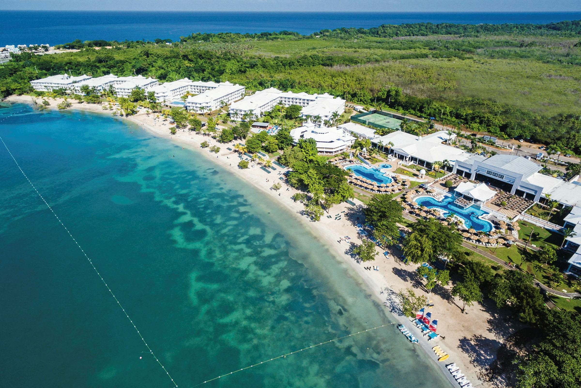 Flygbild av en strand vid ett hotellområde. (AI-genererad text)