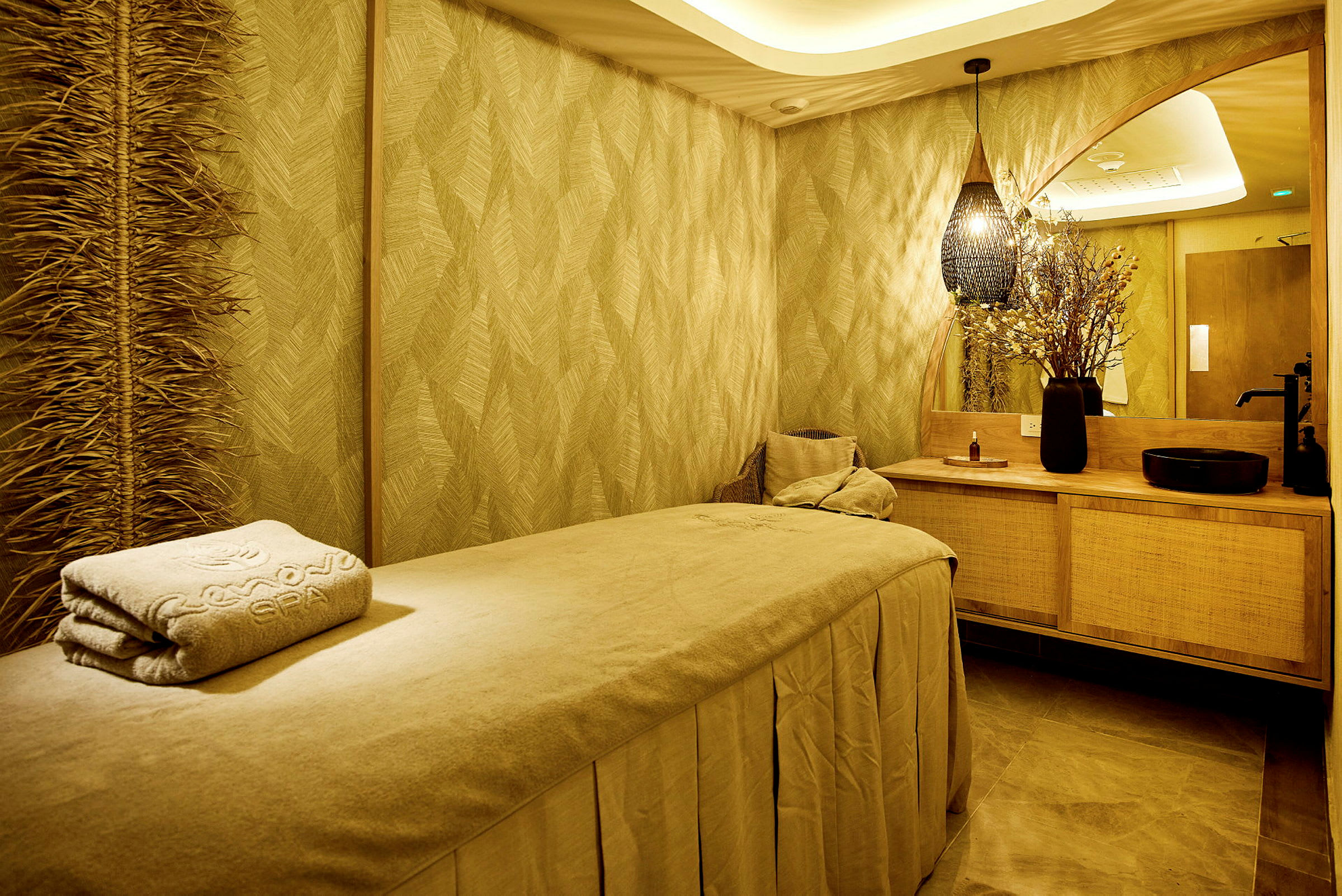 Ett varmt inrett spa-rum med en massagebänk och dekorativa element. (AI-genererad text)