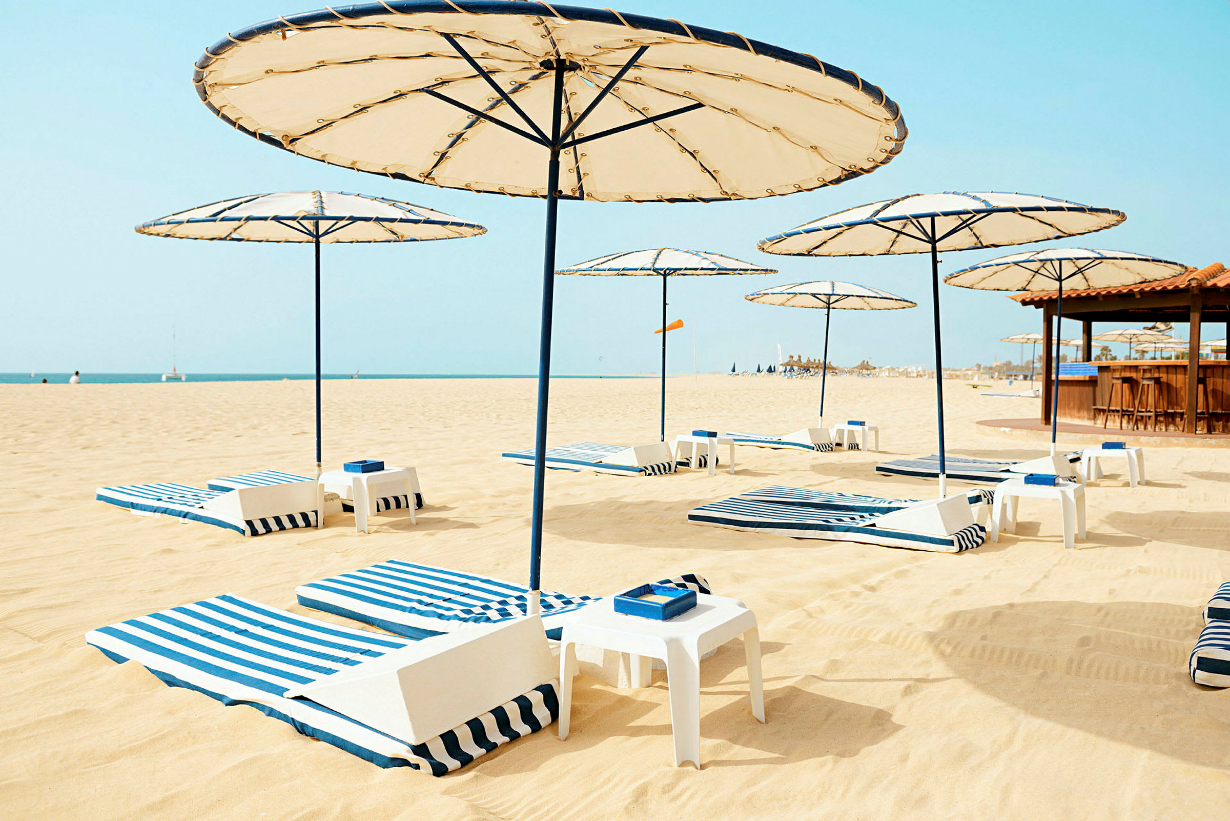 Strand med solstolar och parasoller. (AI-genererad text)
