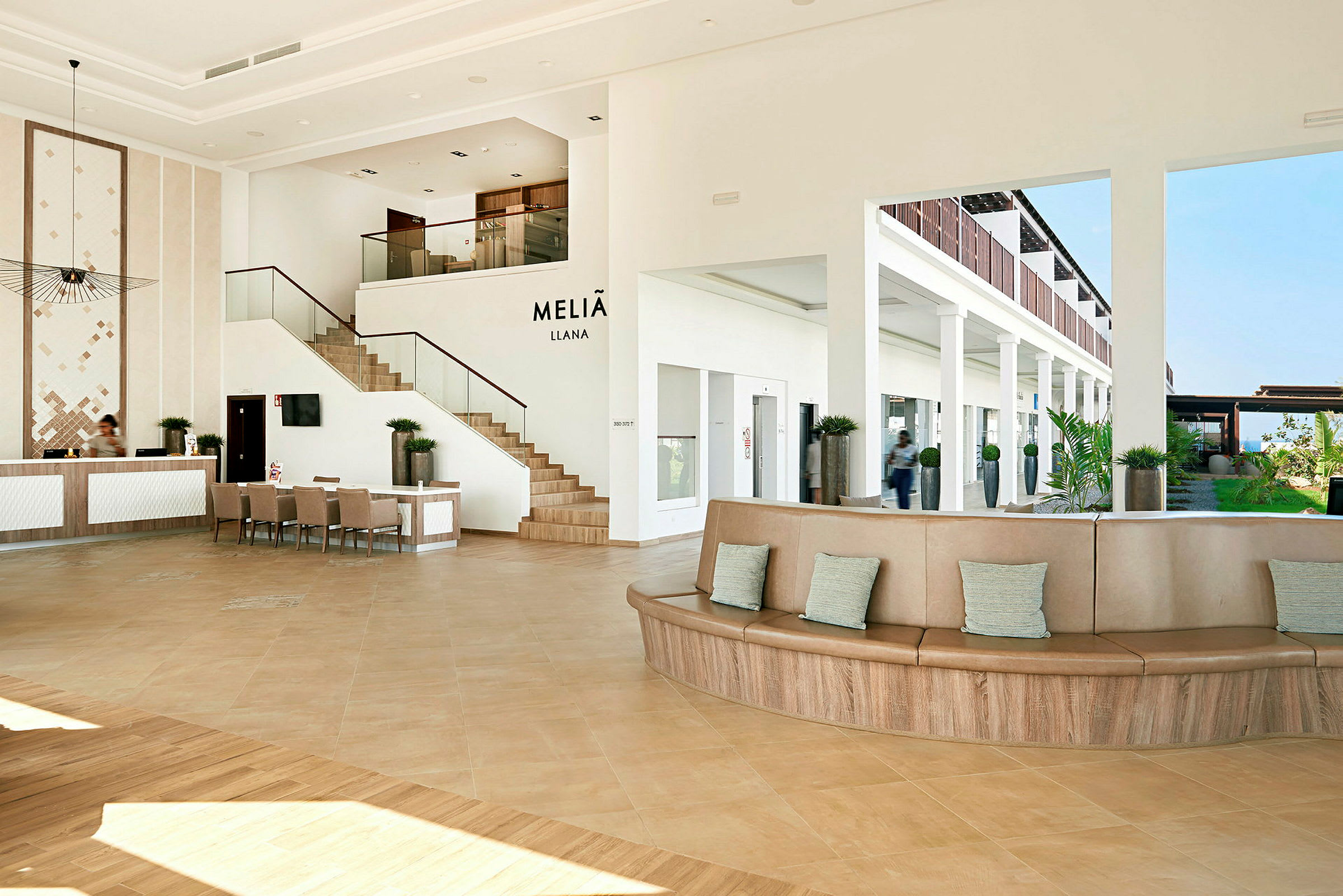 Modernt hotellobbyområde med reception, sittplatser och en trappa. (AI-genererad text)