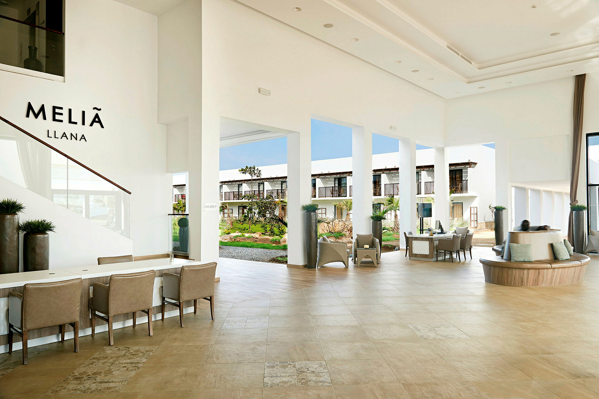 En hotelllobby med möbler och utsikt mot utomhusområdet. (AI-genererad text)
