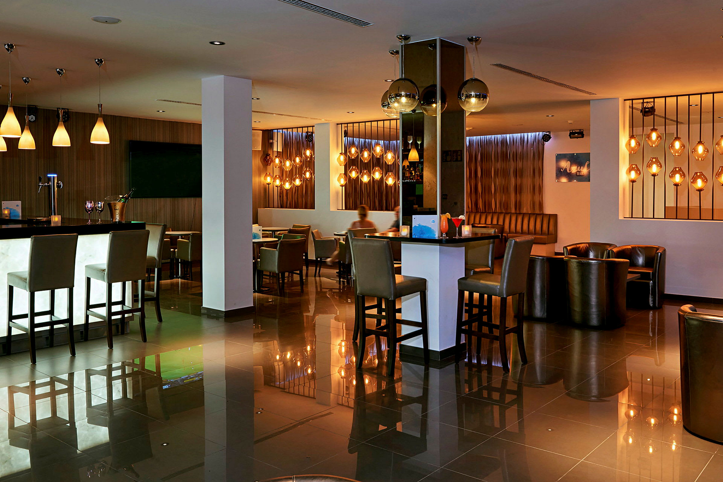 En modern hotellbar med sittplatser och stämningsbelysning. (AI-genererad text)
