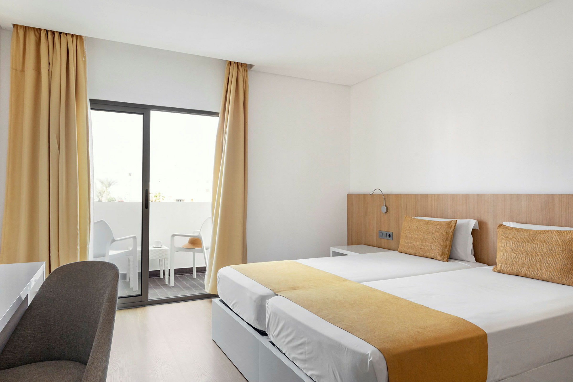 Hotellrum med två enkelsängar och balkong. (AI-genererad text)