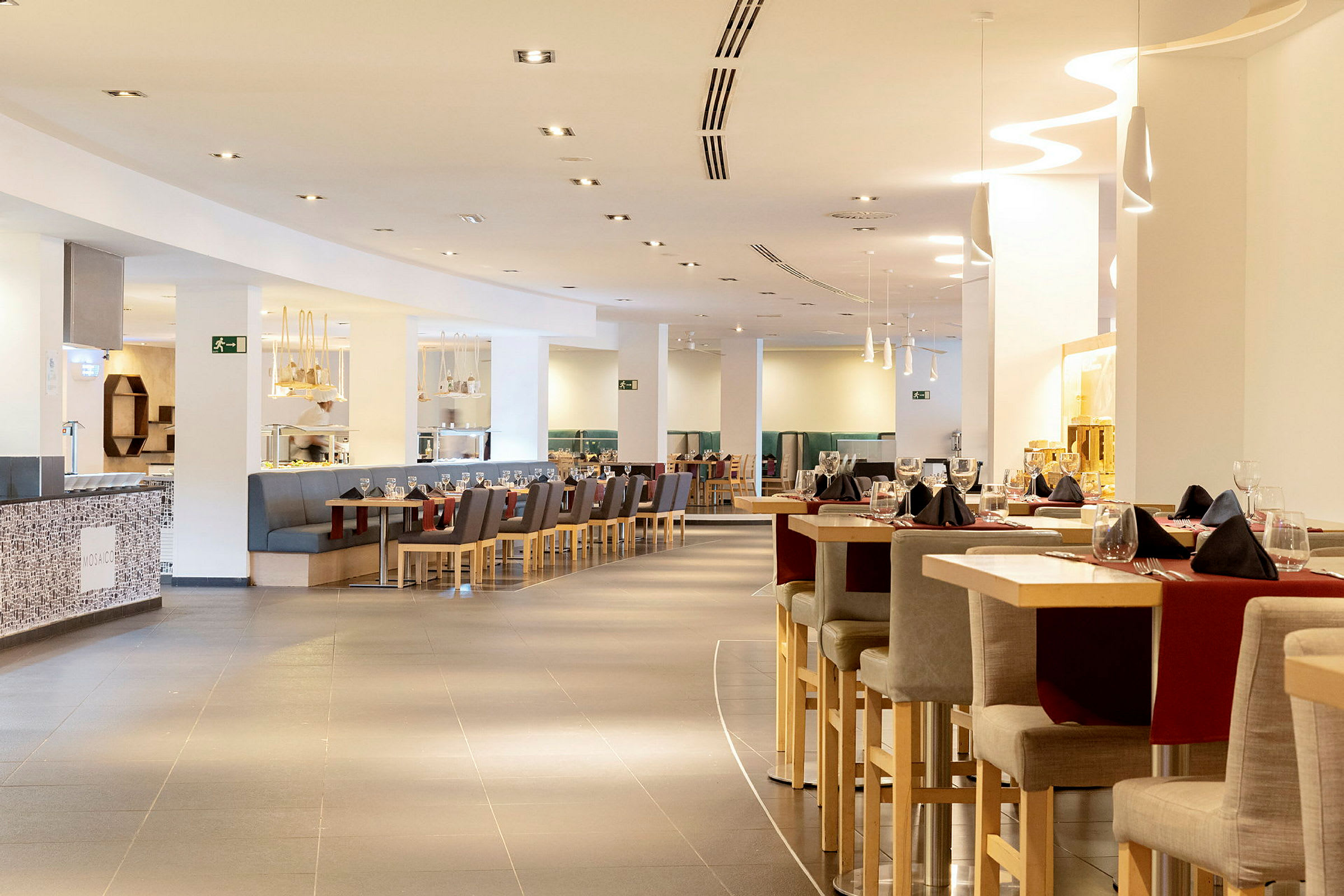 En modern restaurang med sittplatser och bord dekorerade för middag. (AI-genererad text)