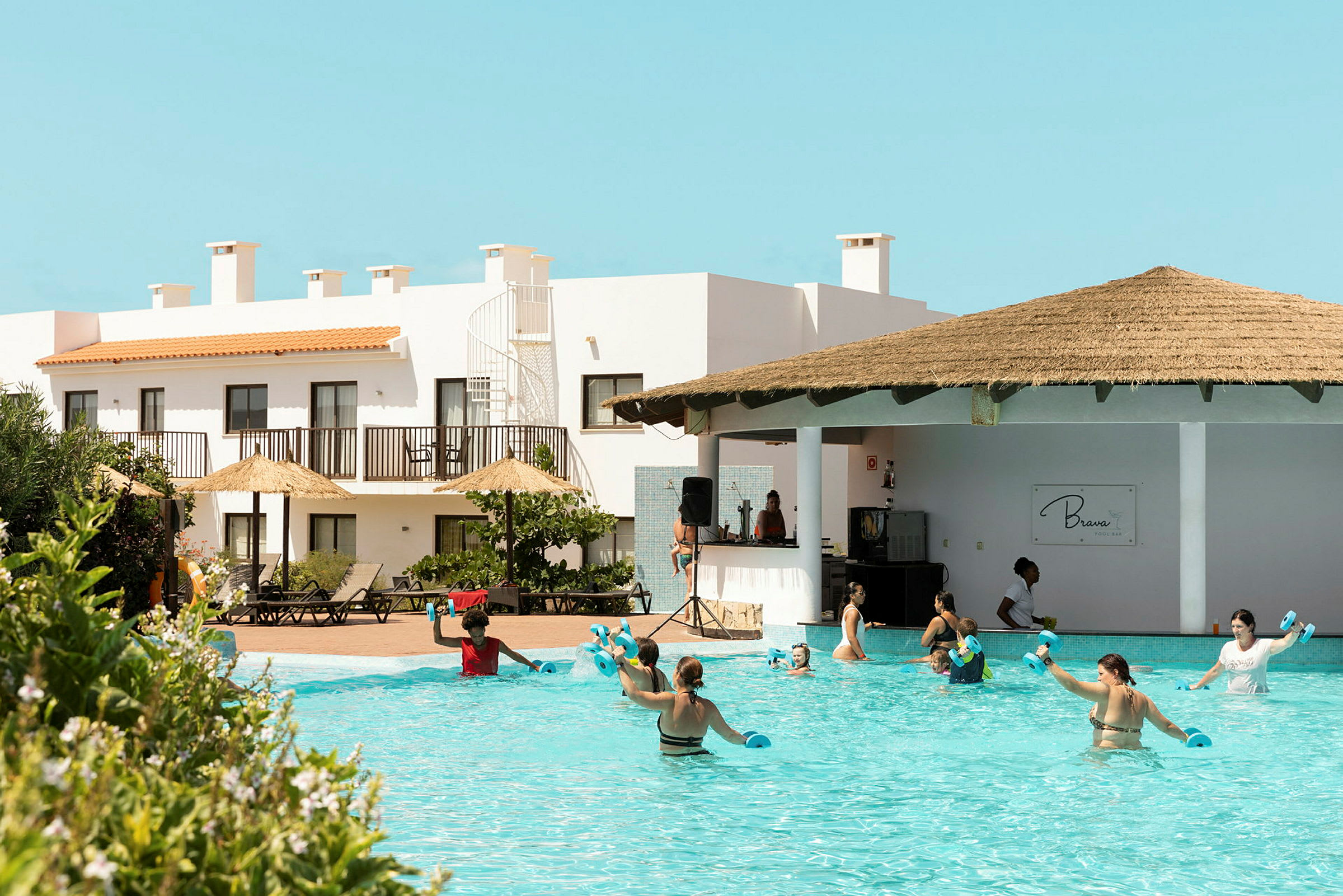 En grupp människor använder poolen vid ett hotellområde. (AI-genererad text)