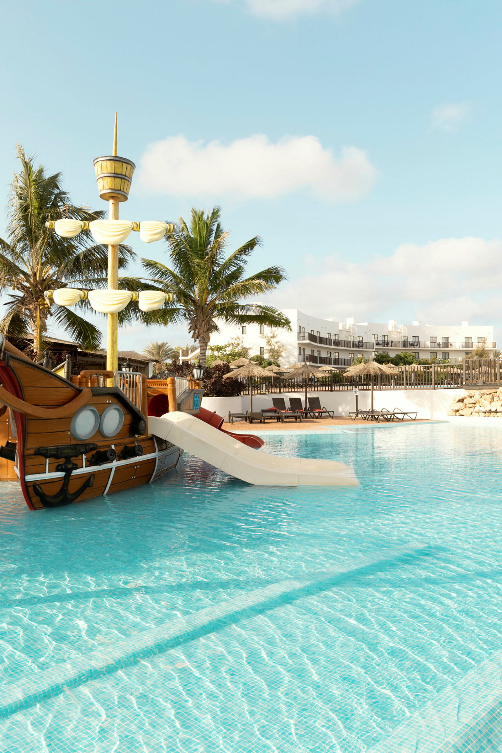 En pool med en lekpiratbåt utrustad med rutschkana. (AI-genererad text)