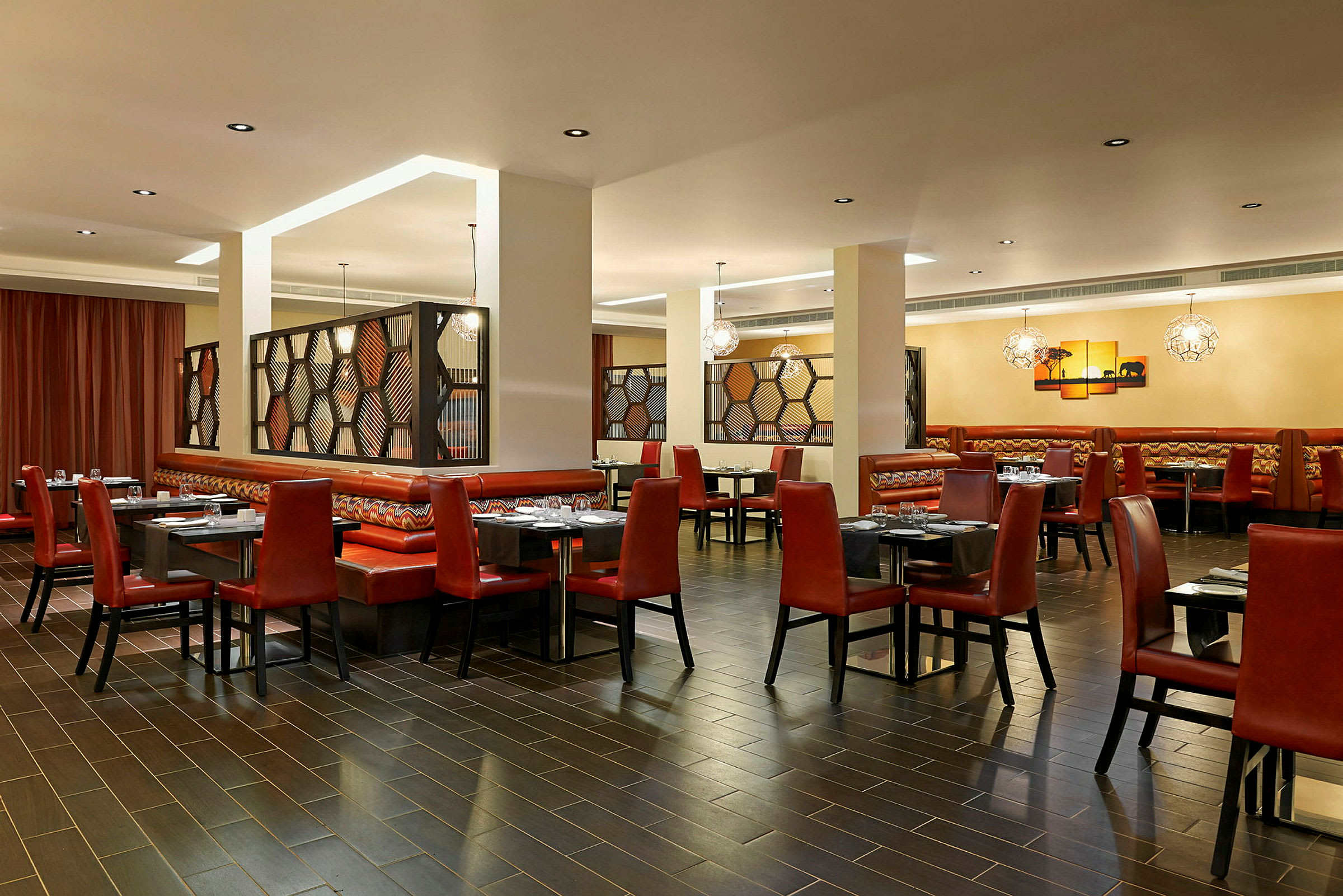 Restaurang med röda stolar, bord och belysning. (AI-genererad text)