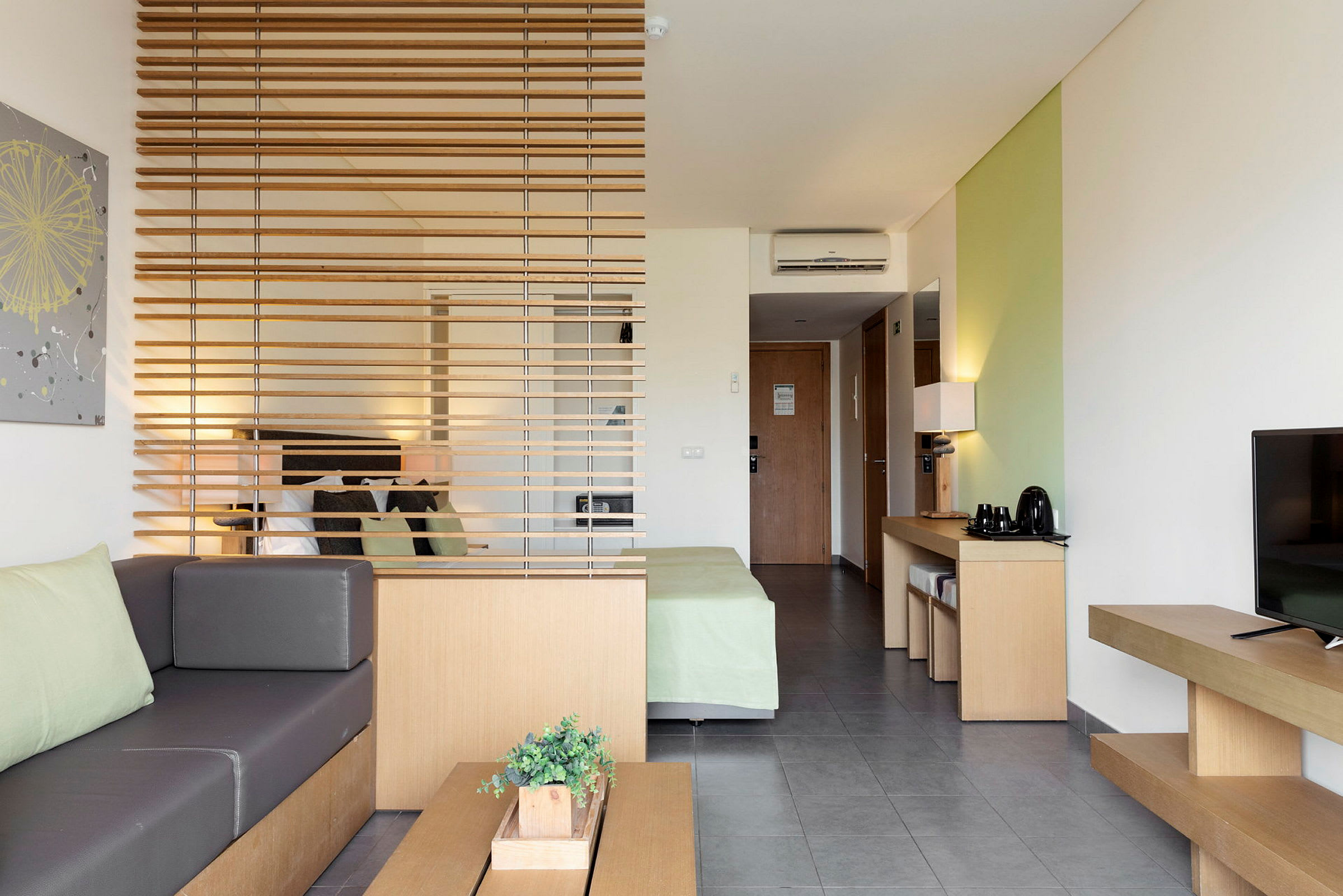 Modernt hotellrum med sittområde, säng och möbler i naturfärger. (AI-genererad text)