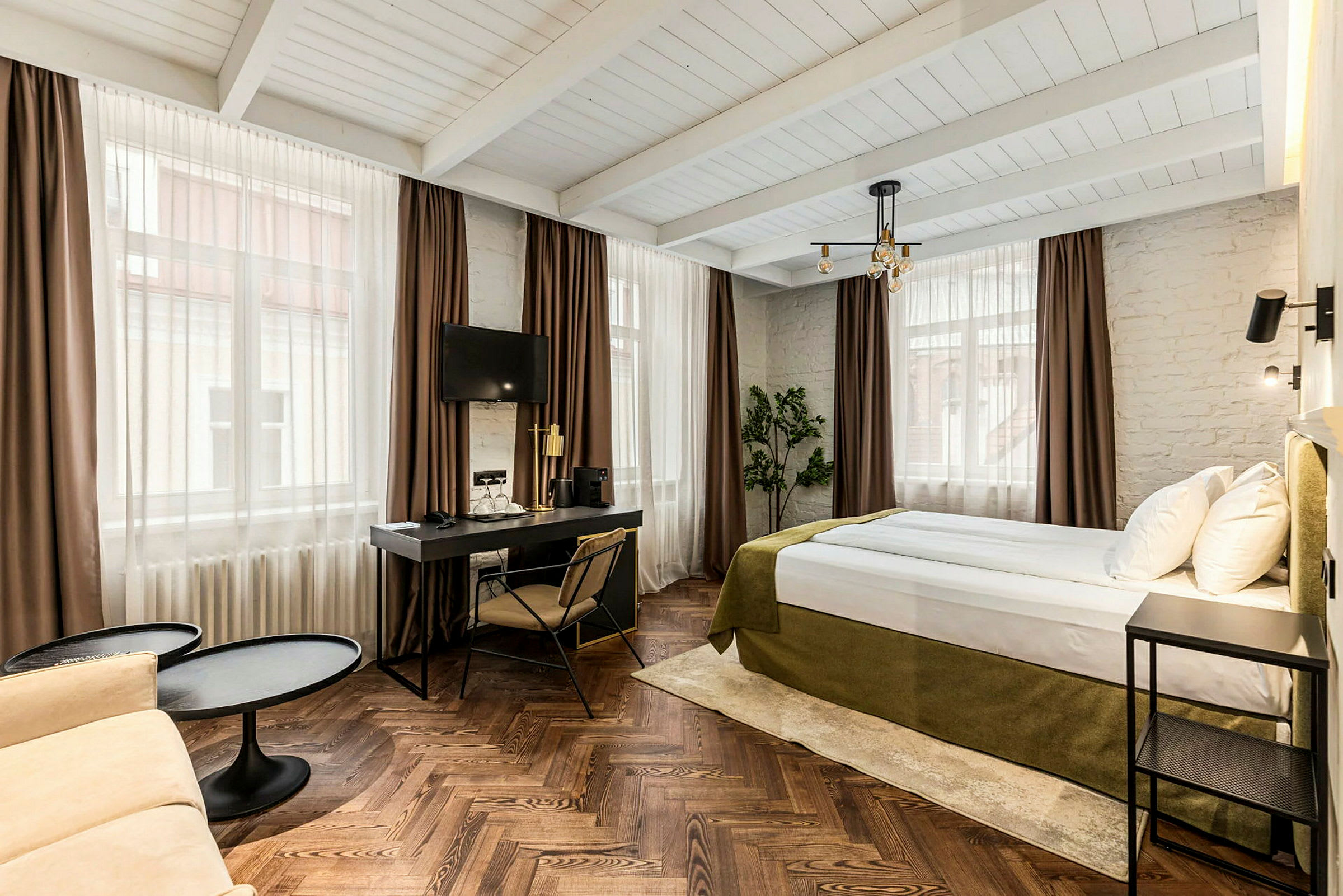 Hotellrum med säng, skrivbord och sittgrupp. (AI-genererad text)