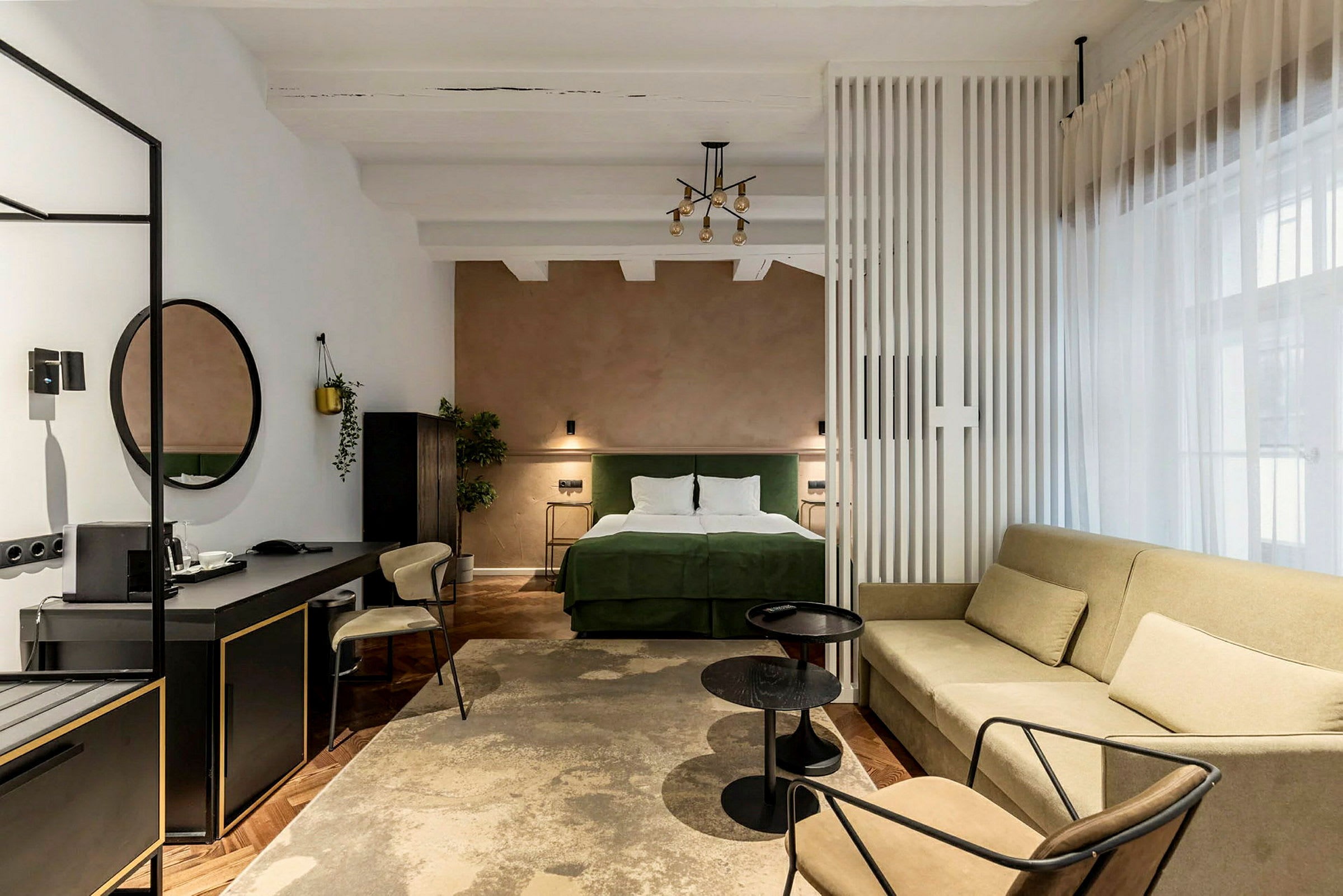 Ett hotellrum med en dubbelsäng, soffa, och skrivbord. (AI-genererad text)