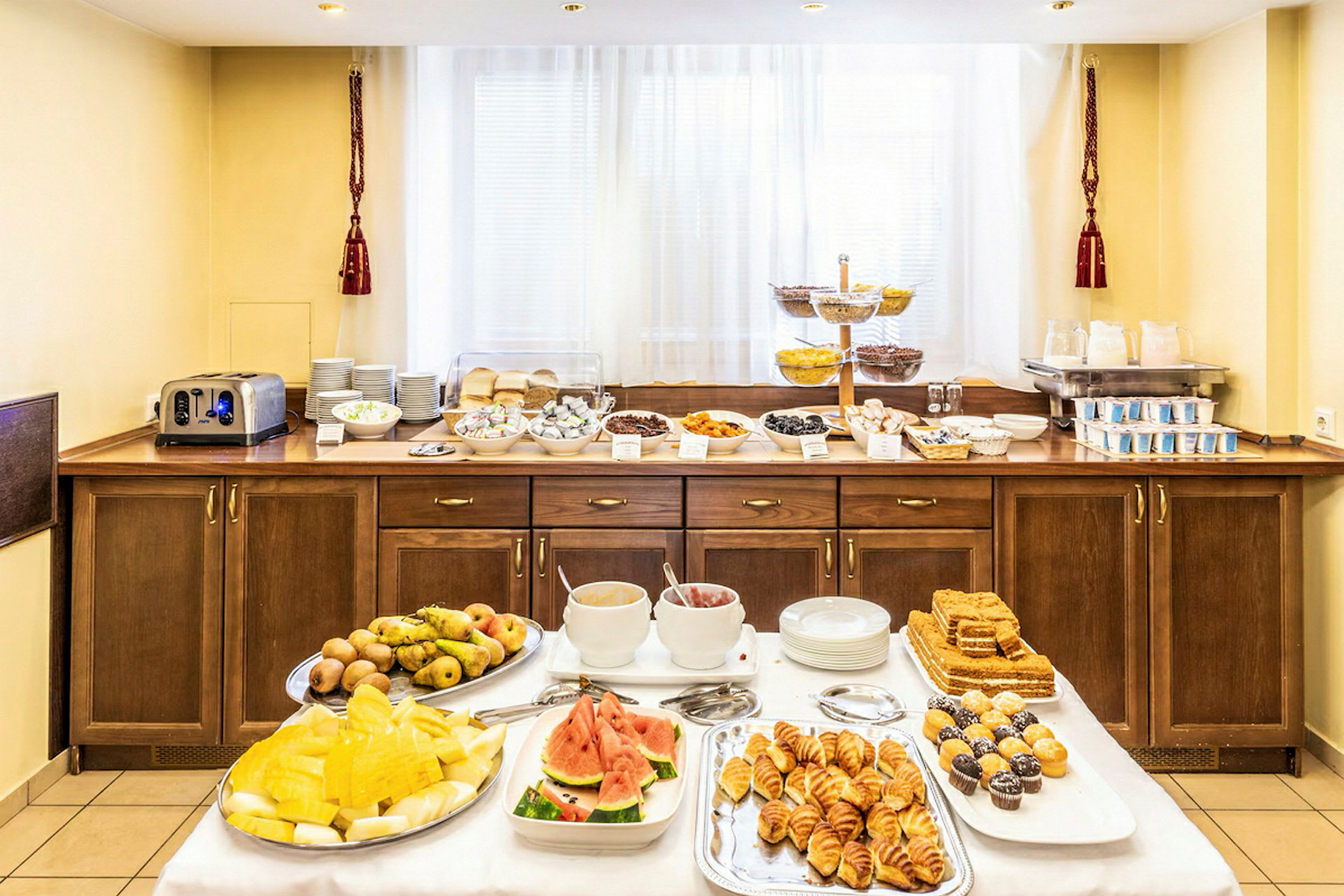 Hotellfrukostbuffé med olika rätter, inklusive frukt, bakverk och drycker. (AI-genererad text)