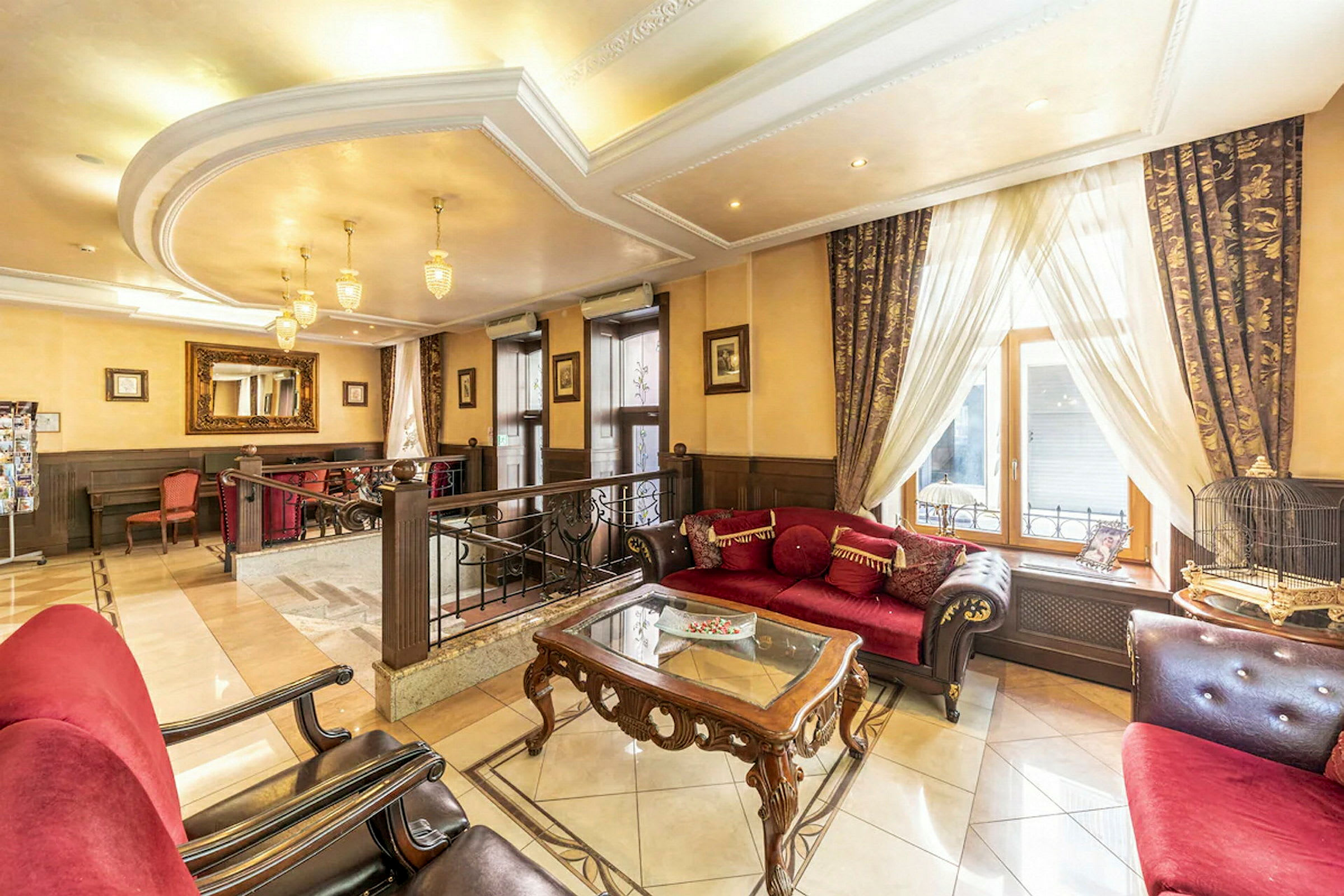 Ljus och elegant hotellobby med röda soffor och klassisk inredning. (AI-genererad text)