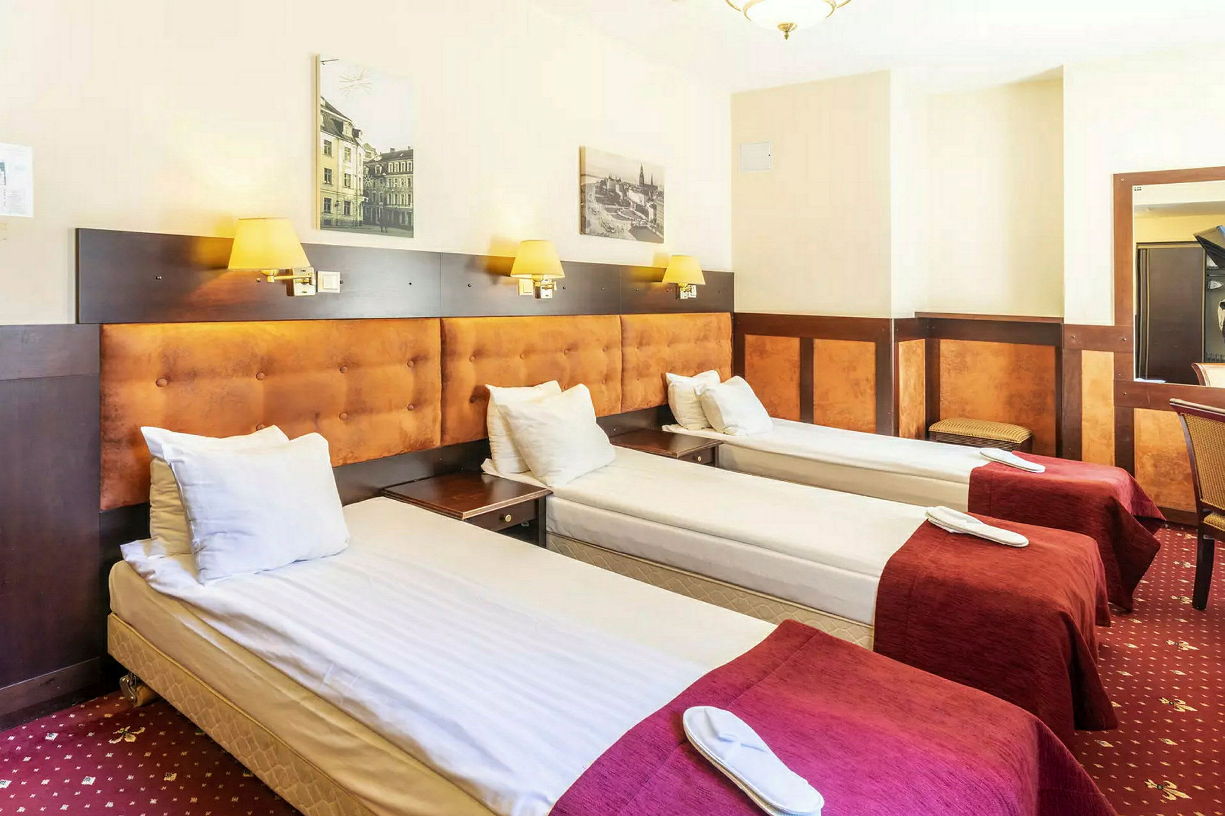 Tre enkelsängar stående på rad i ett hotellrum. (AI-genererad text)