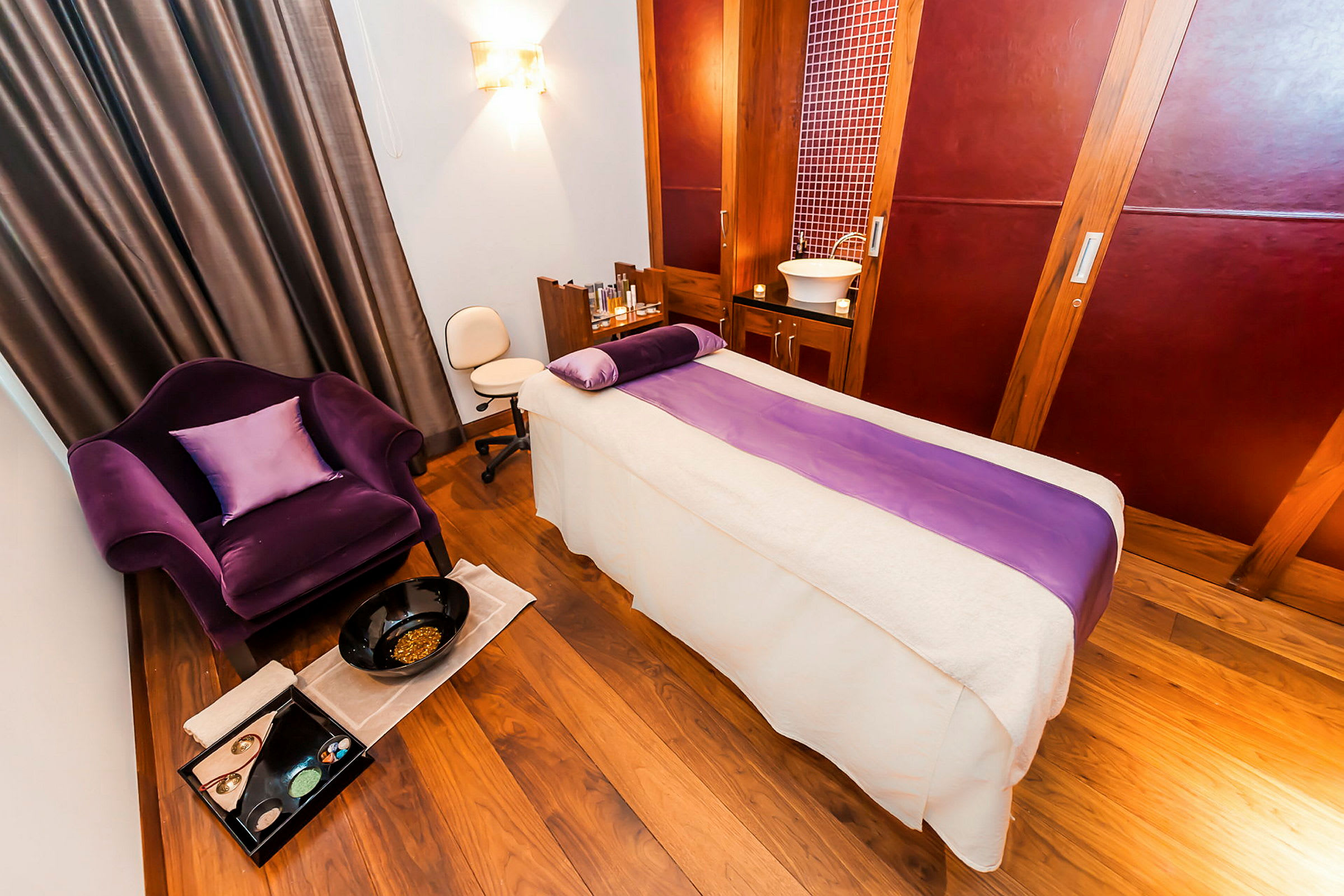 Rum för massage med ett massagebord och en vråkad fåtölj. (AI-genererad text)