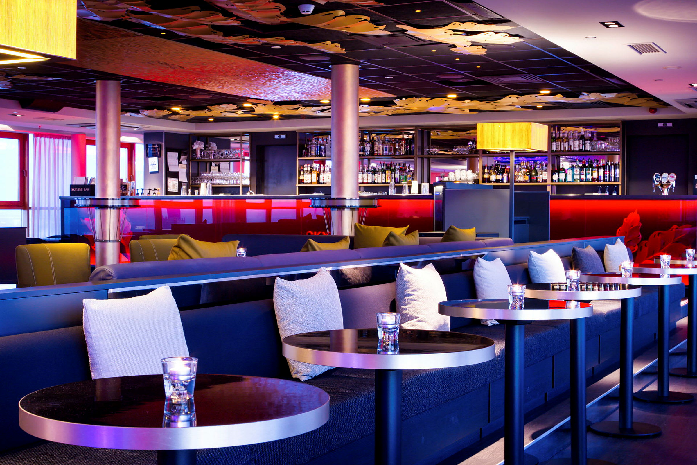 En elegant hotellbar med stilfull inredning, bekväma soffor och ett välfyllt barkabinett. (AI-genererad text)