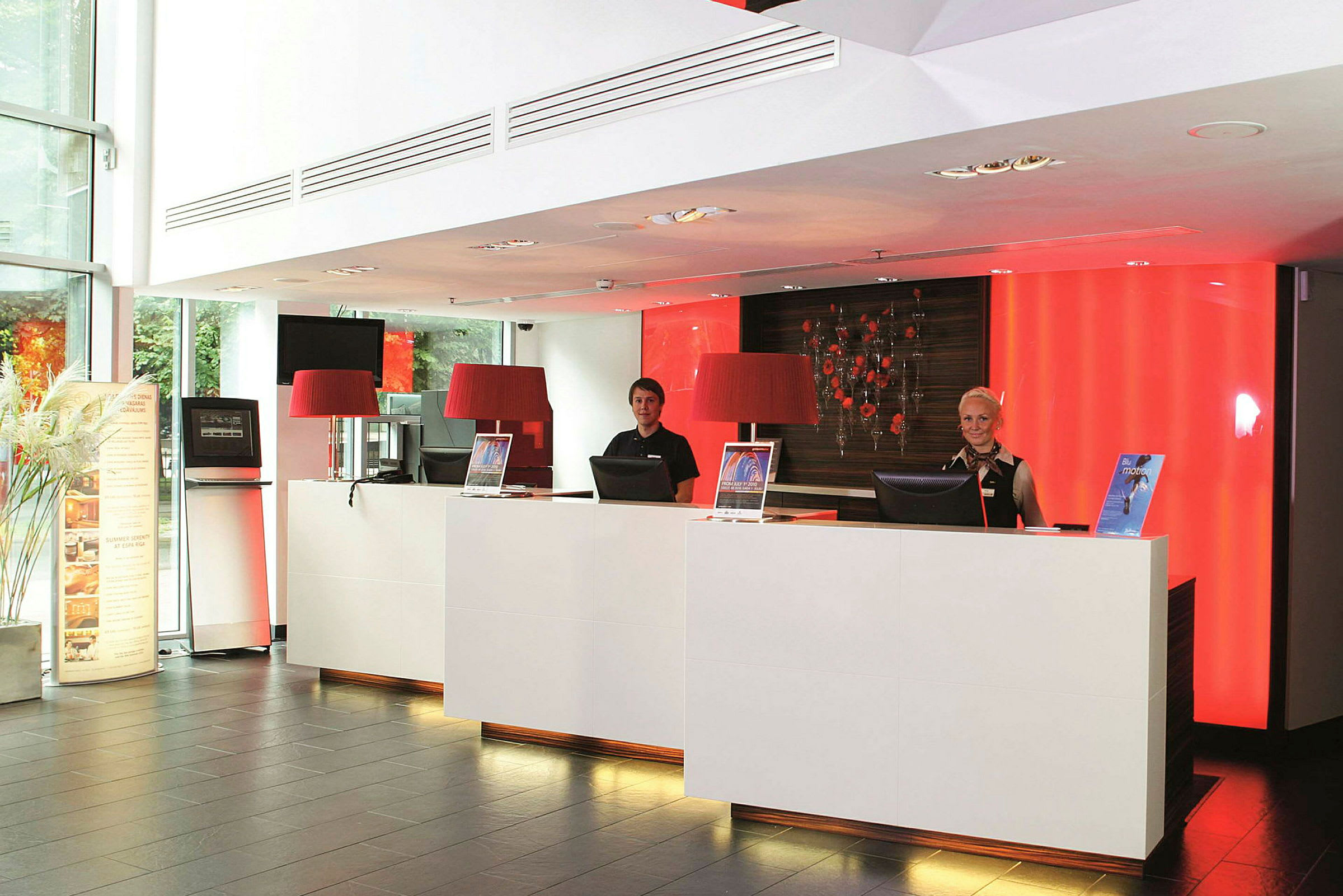 Reception med två receptionsdiskar och röd bakgrundsbelysning. (AI-genererad text)