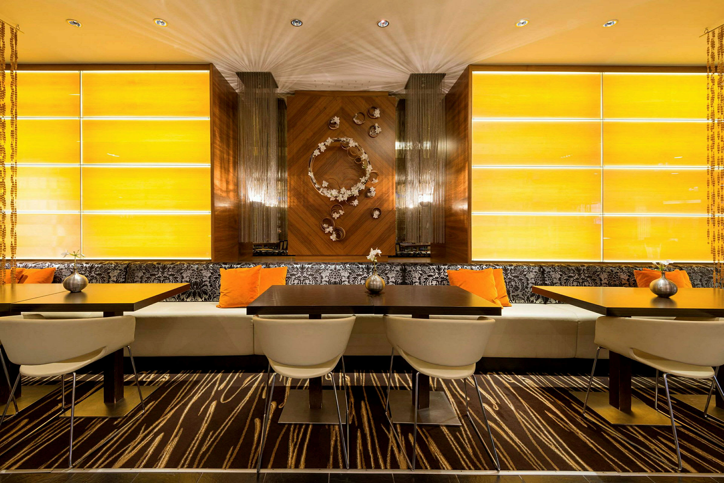 Restaurang med modern inredning, bord, stolar och dekorativa väggpaneler. (AI-genererad text)