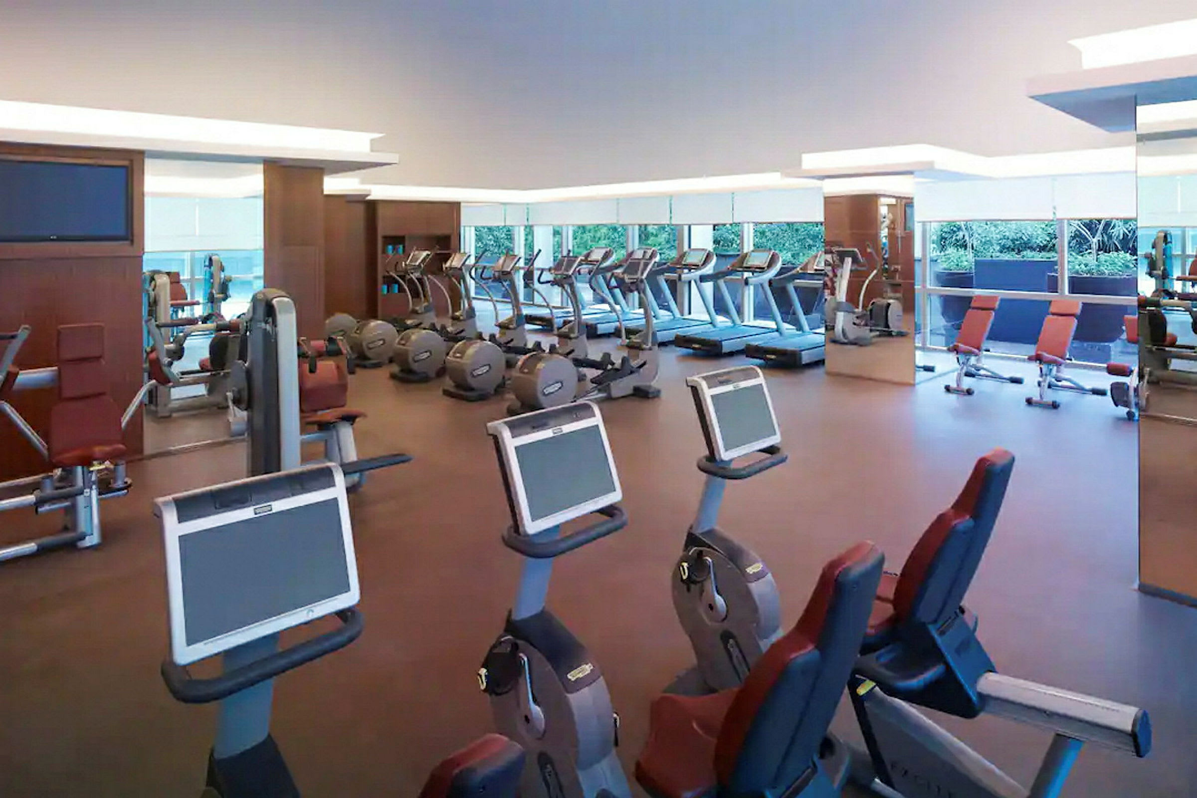 Ett gym med flera träningsmaskiner som löpband, motionscyklar och styrketräningsutrustning. (AI-genererad text)