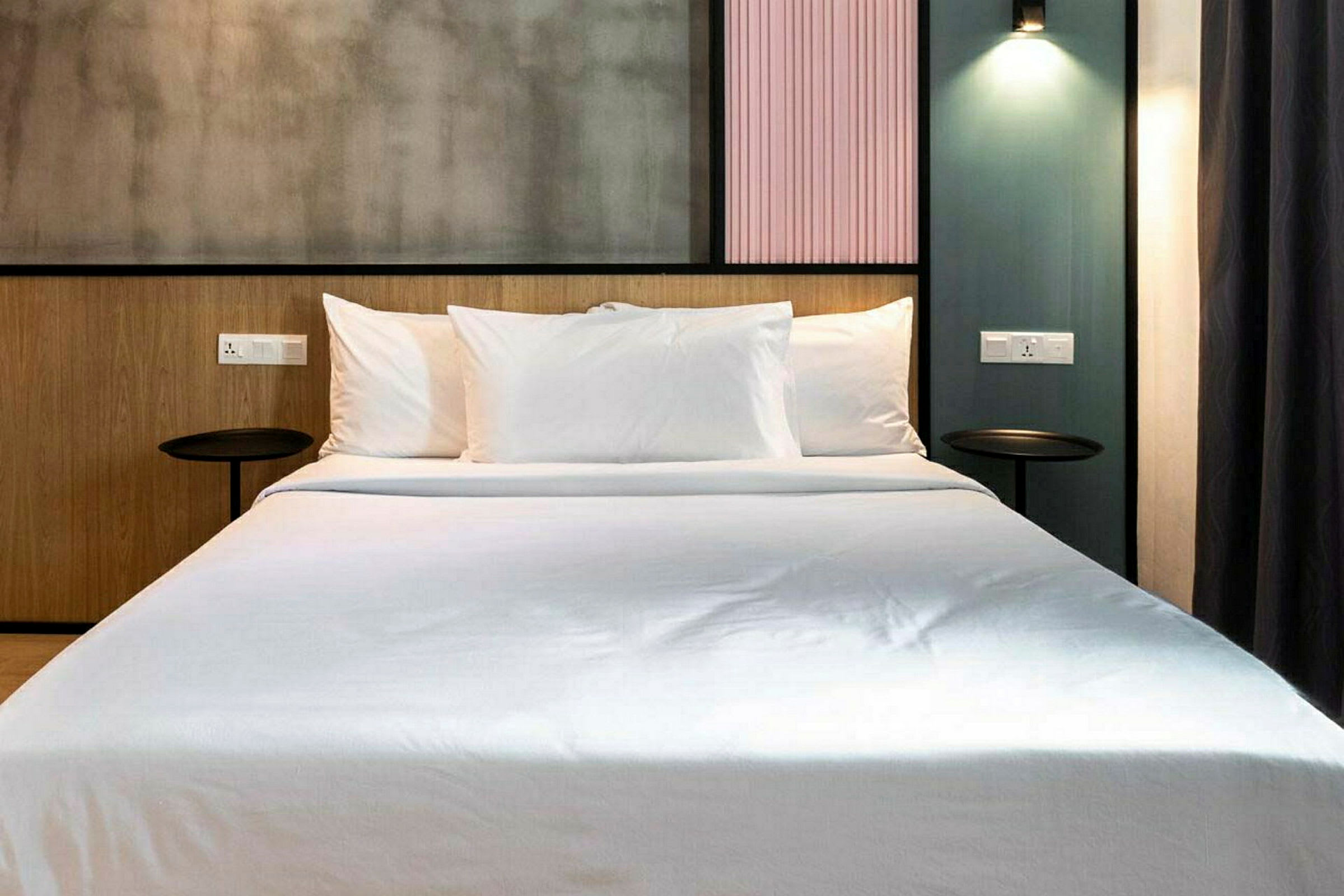 Ett modernt hotellrum med en uppbäddad säng och stilren bakgrund. (AI-genererad text)