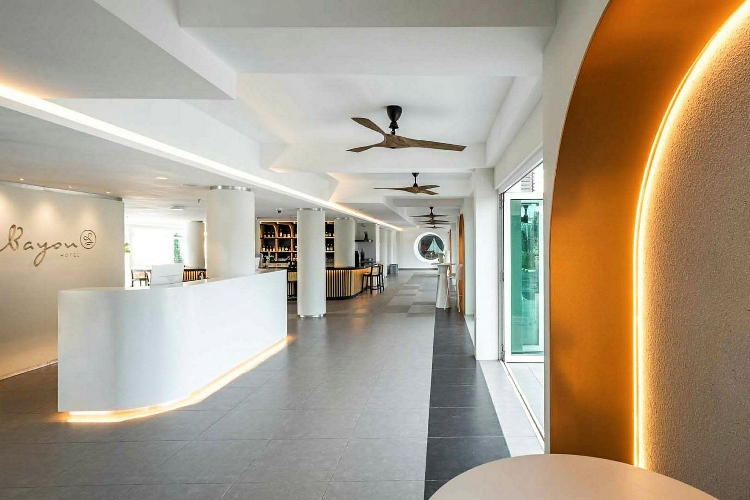 En modern och elegant hotellreception med vita möbler, dekorativa takfläktar och en varm belysning. (AI-genererad text)