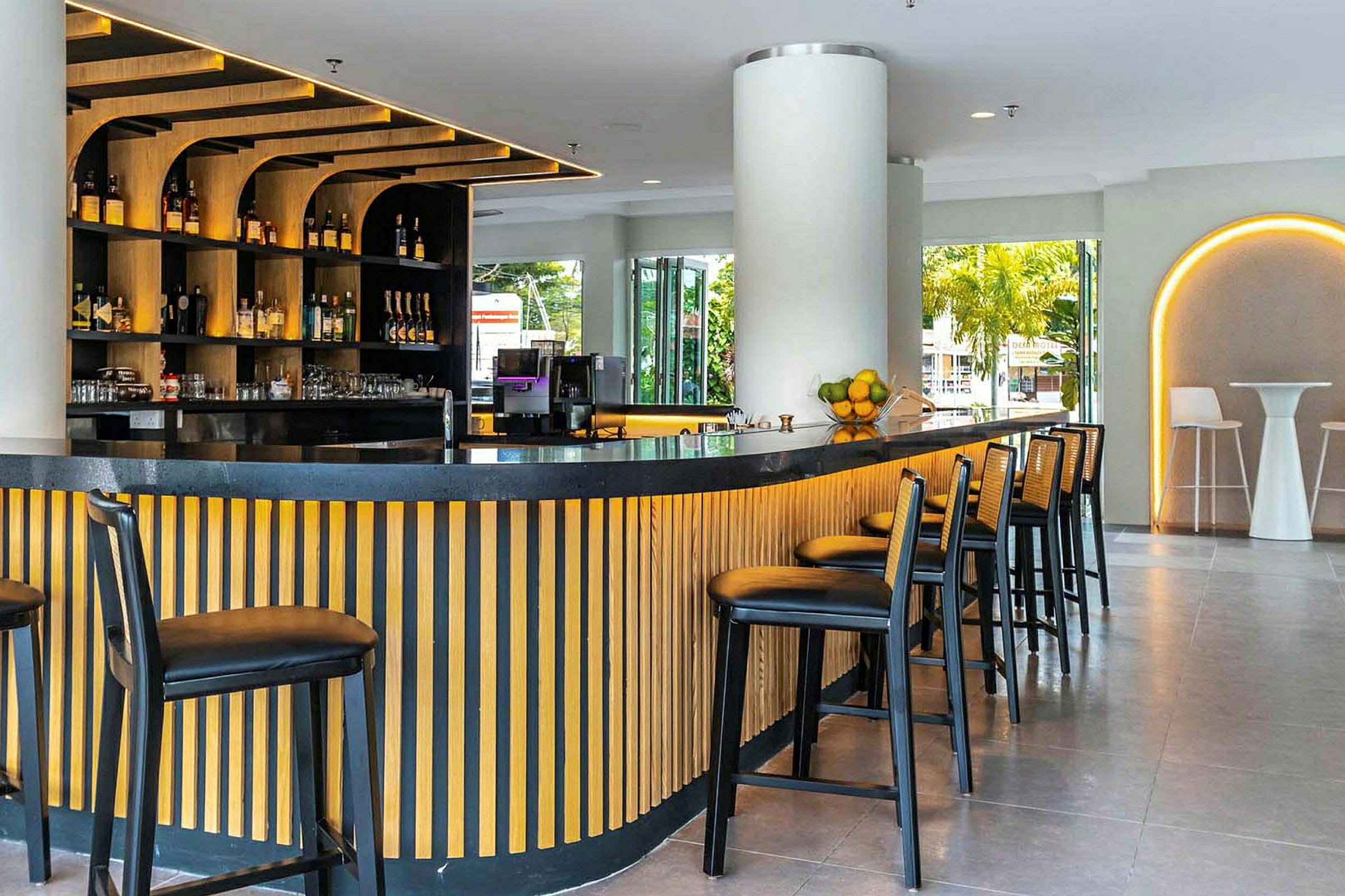 En modern bar med trädetaljer, högstolar och flaskor i hyllor. (AI-genererad text)