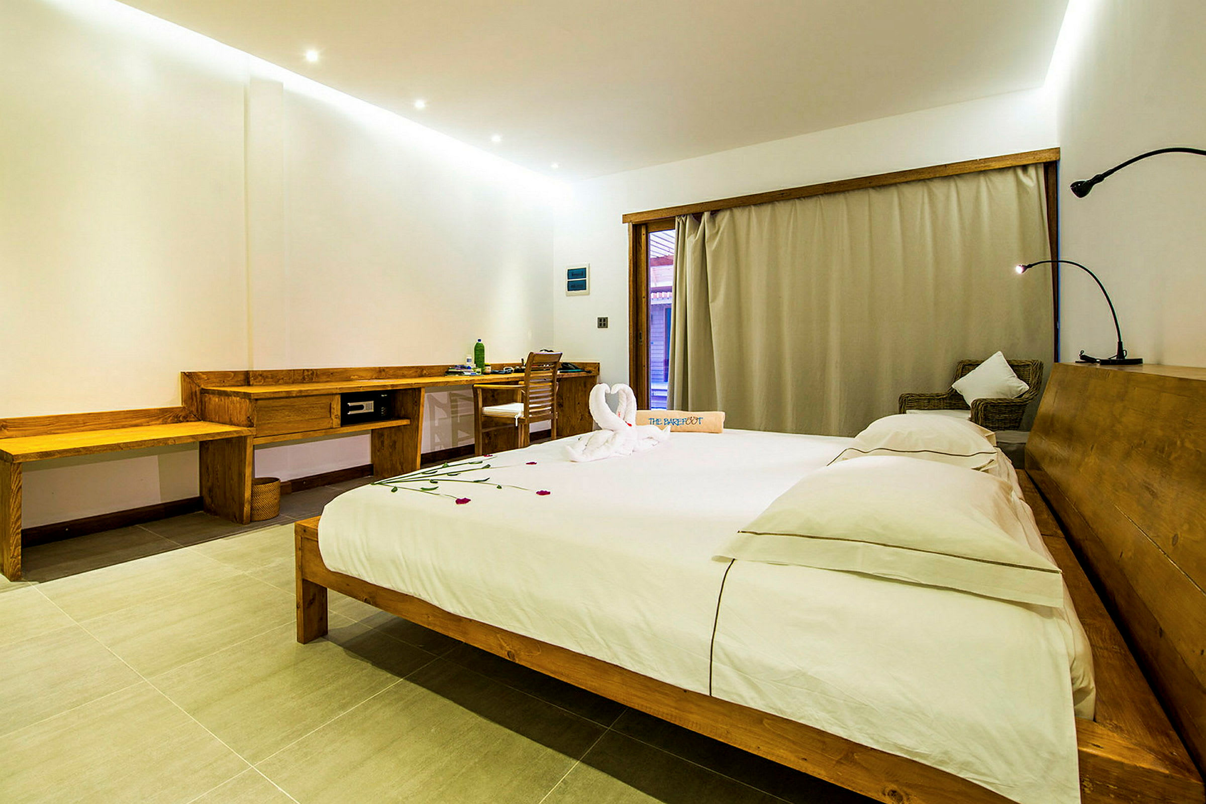 Ett rymligt hotellrum med en stor säng, skrivbord och sittgrupp. (AI-genererad text)