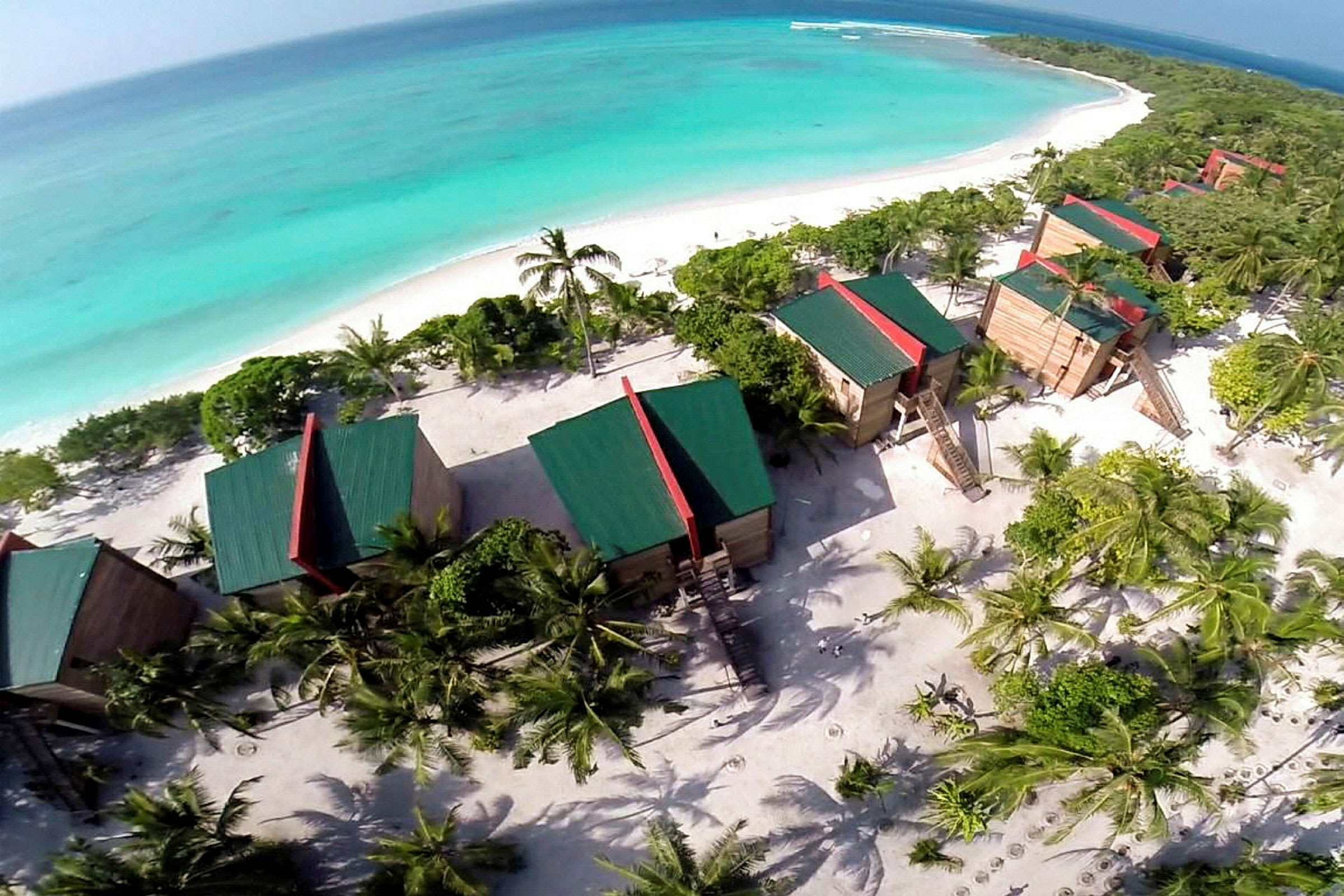 Flygbild av resort vid stranden med hav i bakgrunden. (AI-genererad text)