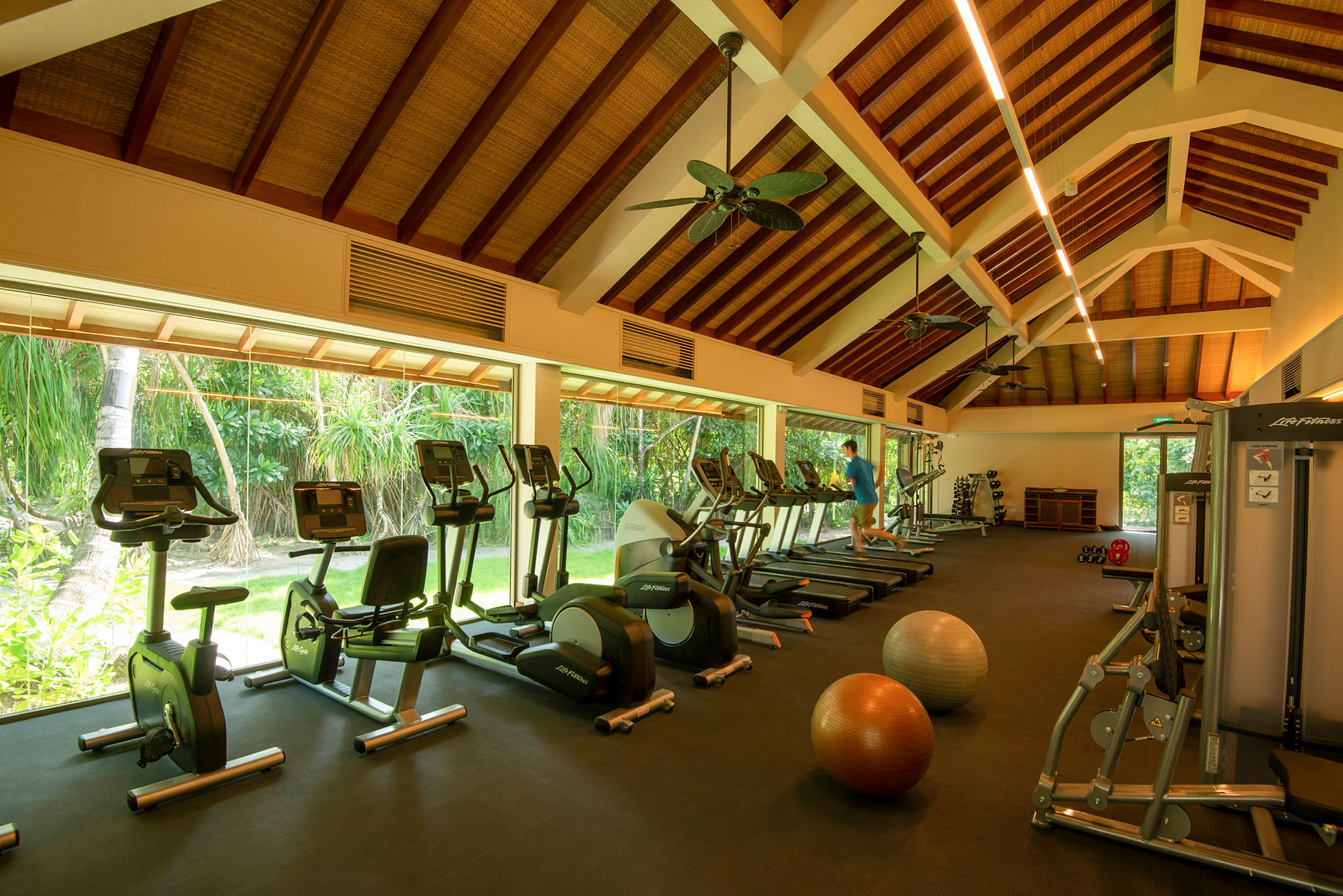 Ett gym med träningsmaskiner och stora fönster. (AI-genererad text)