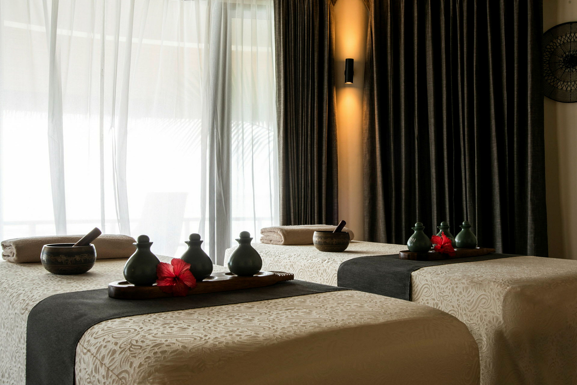Spa-rum med två massagebänkar och dekorationer. (AI-genererad text)
