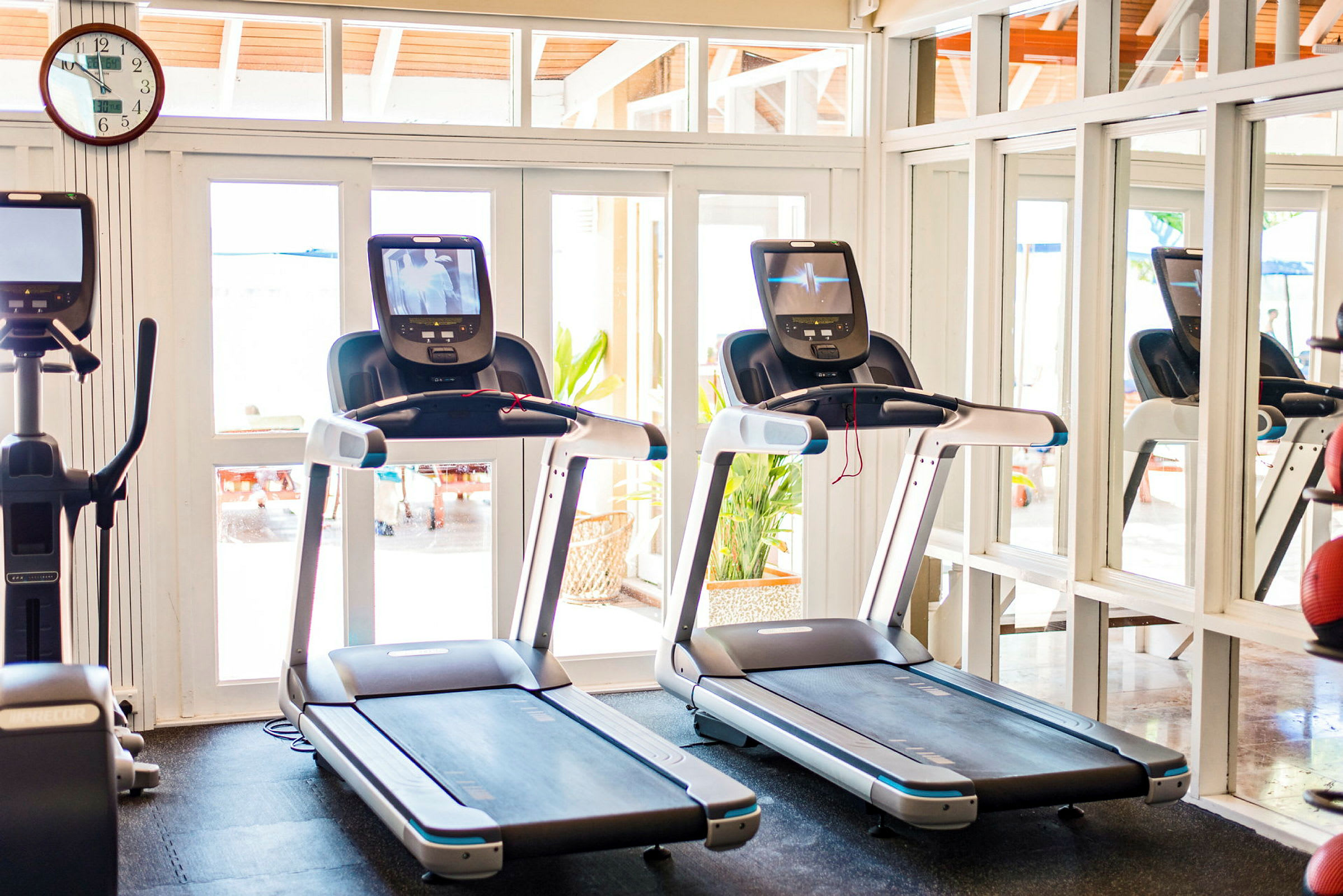 Två löpband i ett ljusgym med spegelvägg. (AI-genererad text)