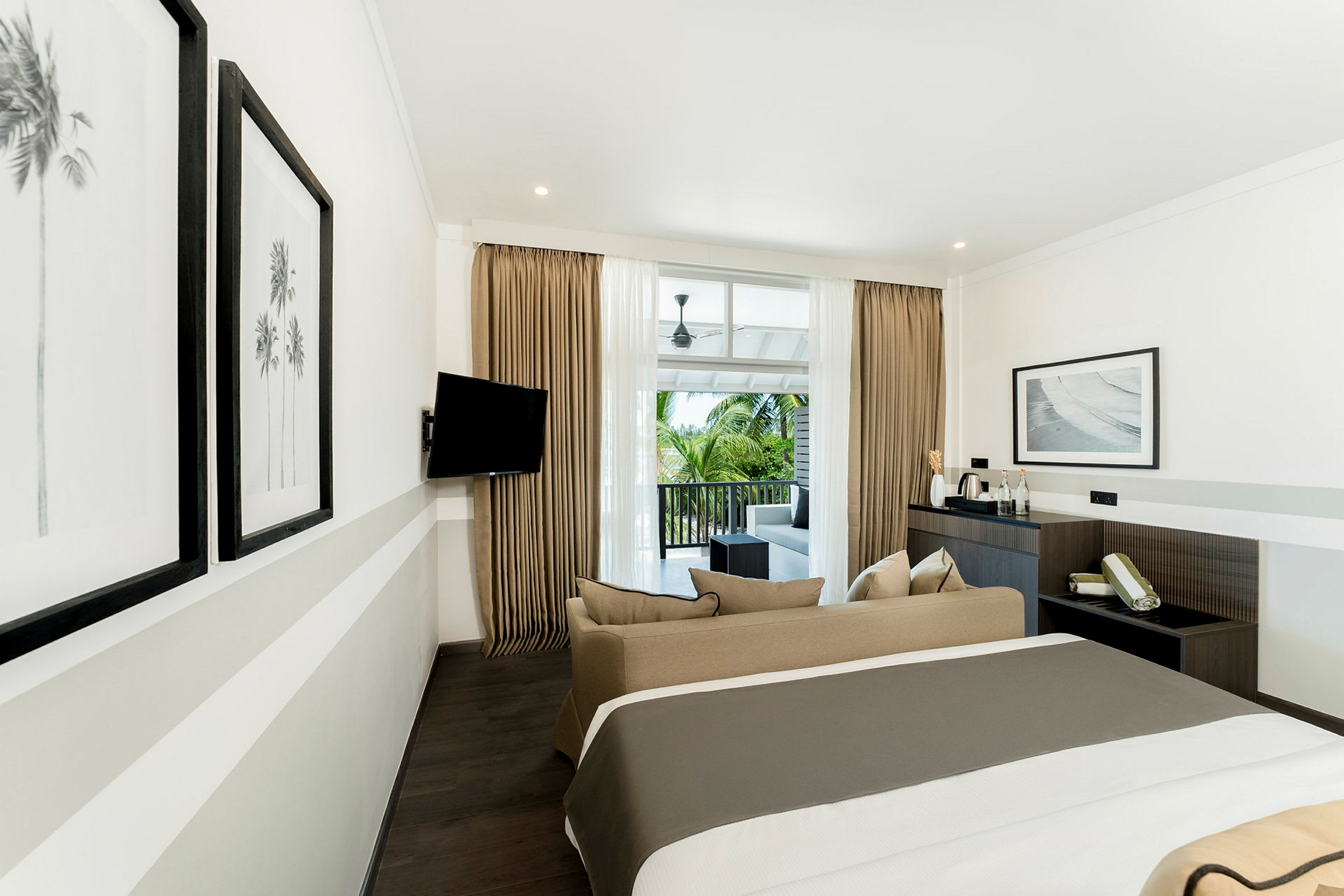 Ett modernt hotellrum med en dubbelsäng, soffa och balkong med utsikt. (AI-genererad text)