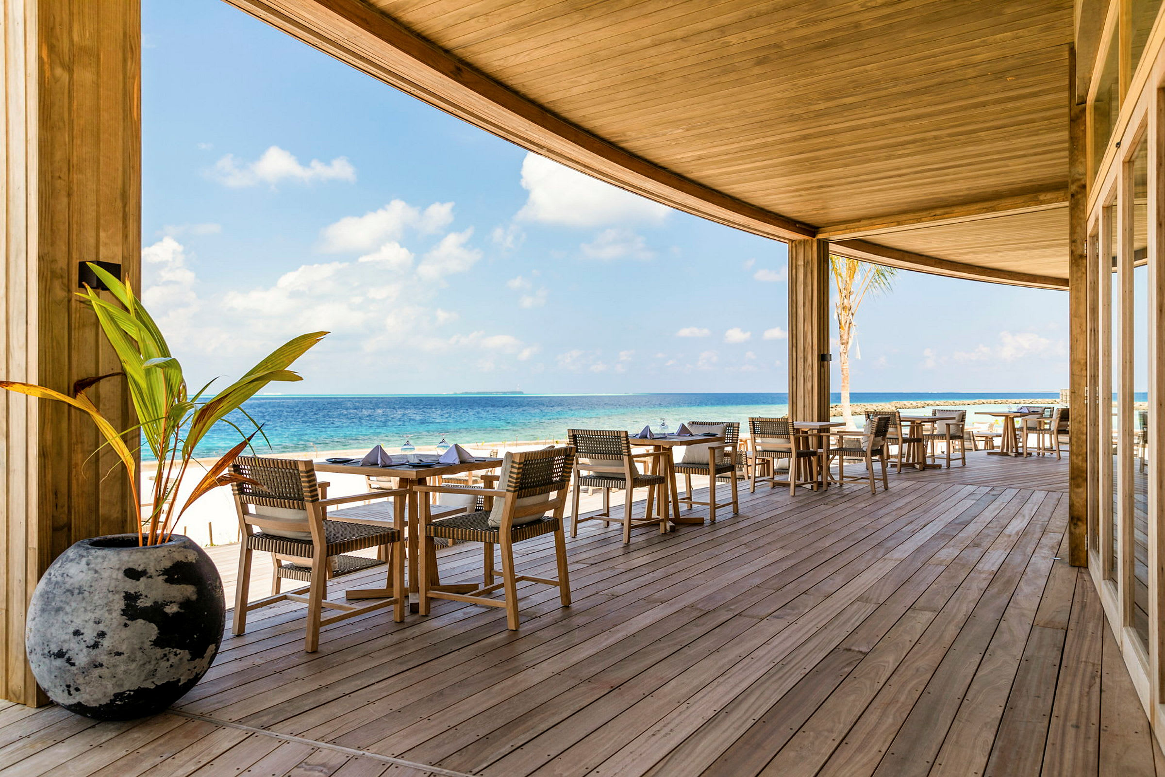 Utomhusrestaurang på en veranda med utsikt över havet. (AI-genererad text)