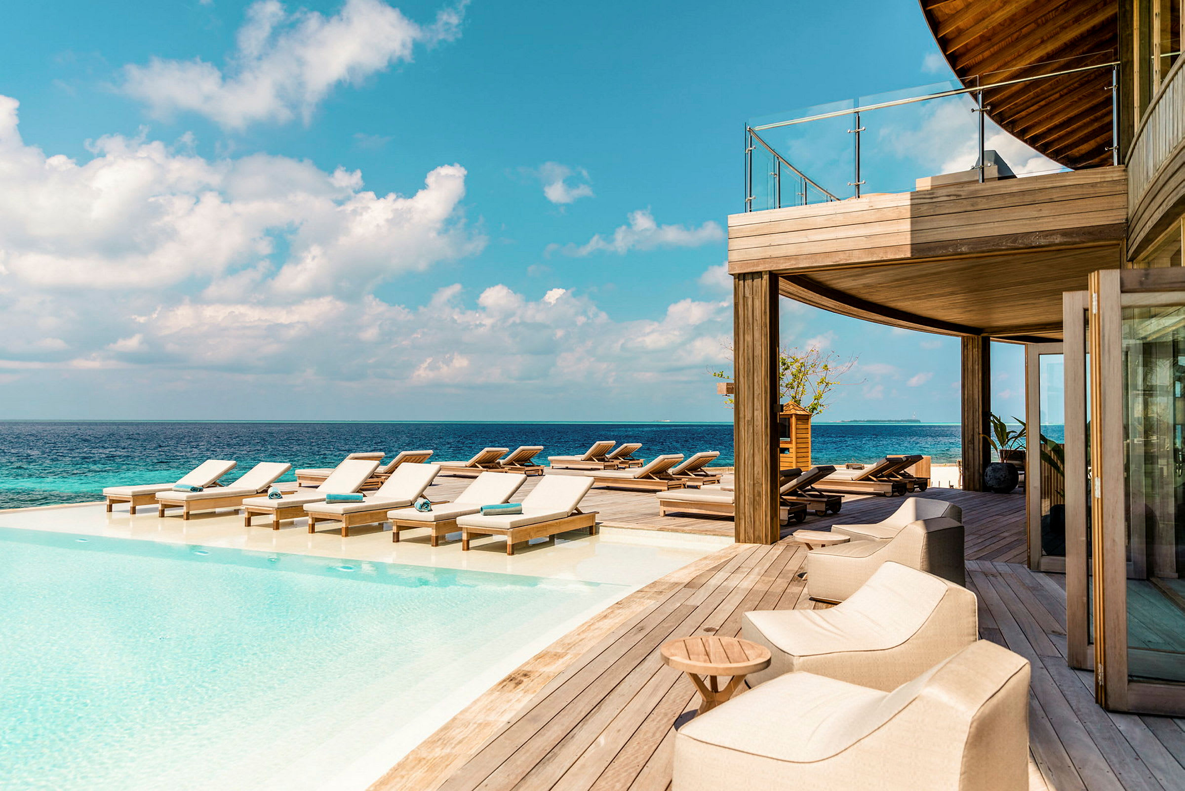 En infinitypool med solstolar nära havet. (AI-genererad text)