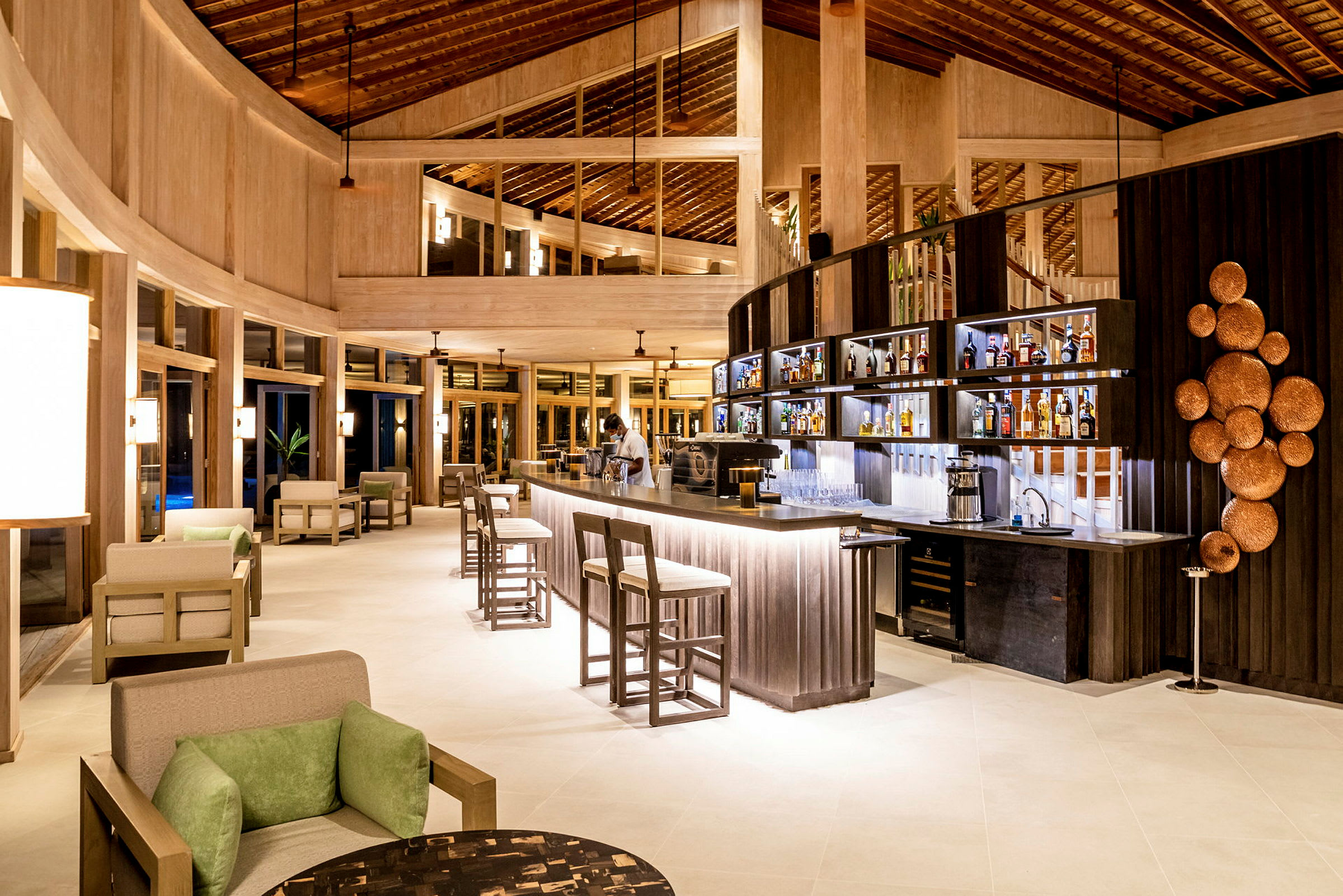 Interiör av en modern lobby med bar, sittplatser och dekorativ belysning. (AI-genererad text)