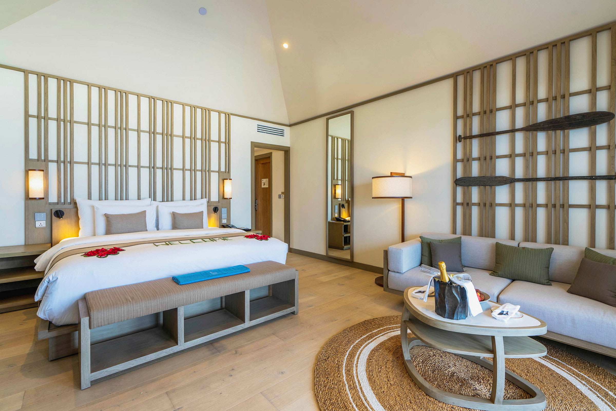 Ett hotellrum med en dubbelsäng, soffa, soffbord och dekorationer. (AI-genererad text)