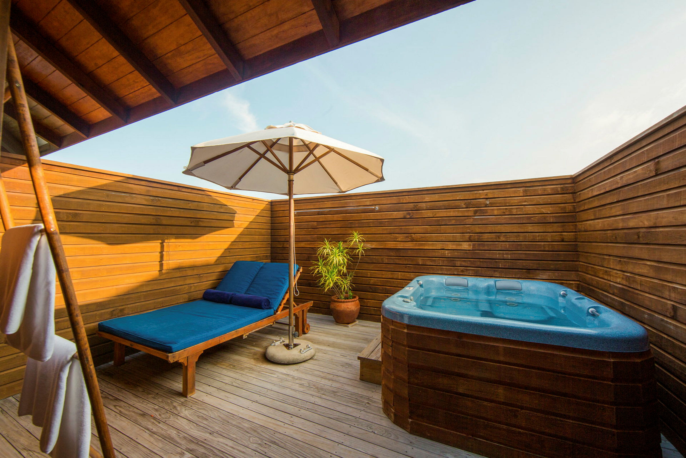 En privat terrass med solstol, parasoll och bubbelpool. (AI-genererad text)