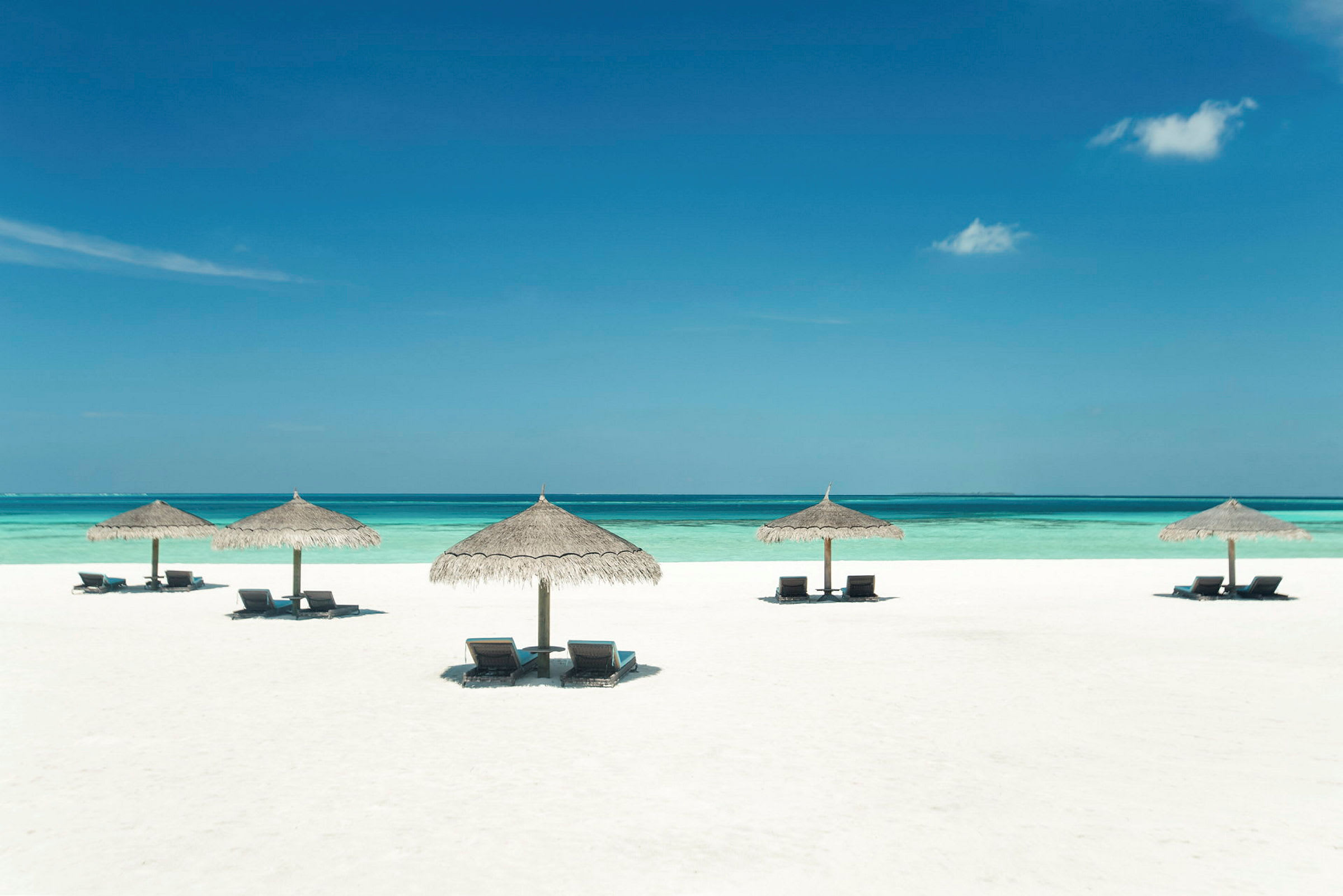 Strand med parasoller och solstolar vid havet. (AI-genererad text)