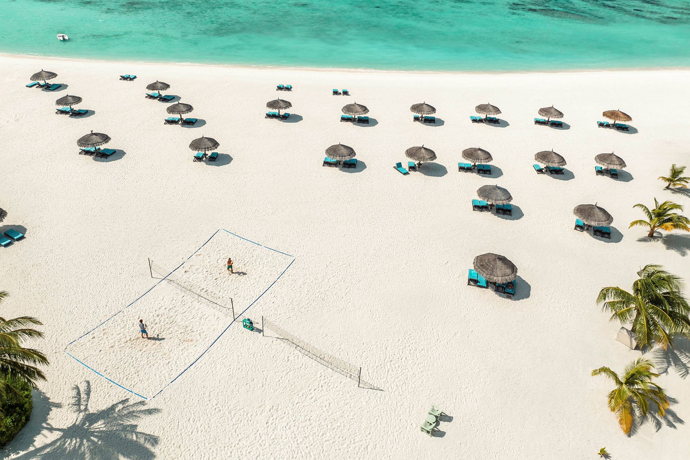Strand med parasoller, solstolar och ett volleybollnät. (AI-genererad text)