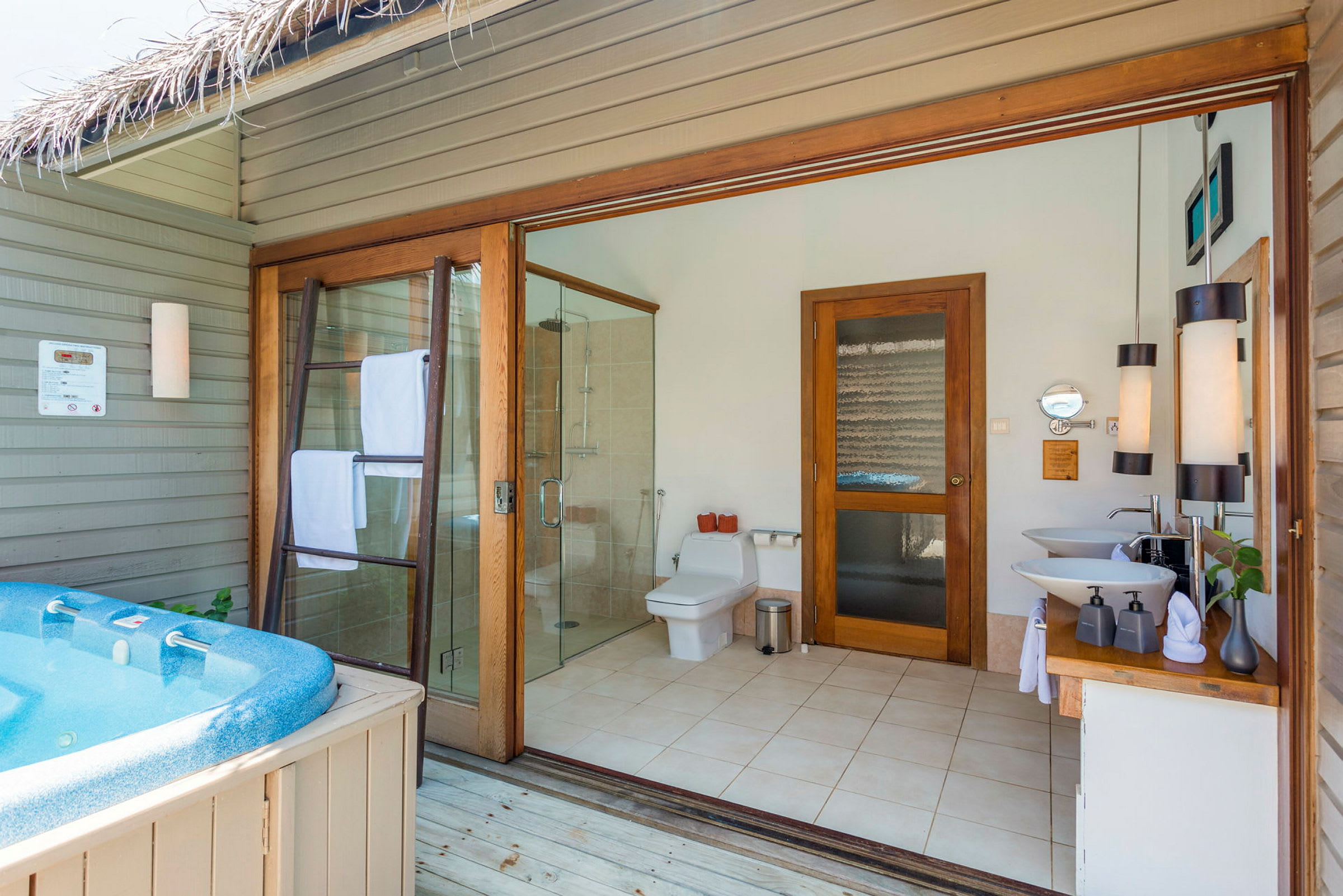 Badrum med öppen planlösning och jacuzzi utanför. (AI-genererad text)