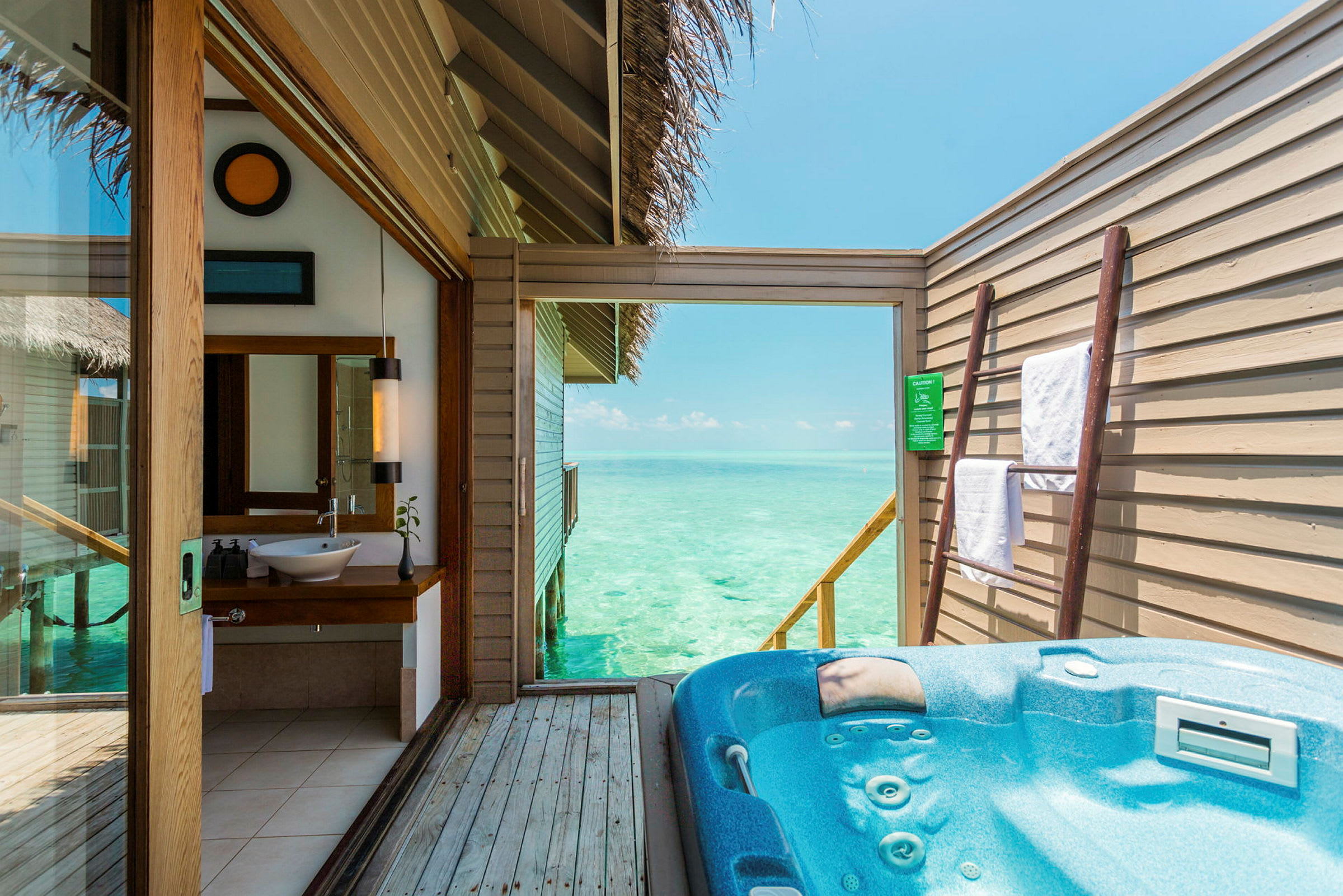 En uteplats med jacuzzi och utsikt över havet, samt en badrumsinteriör. (AI-genererad text)