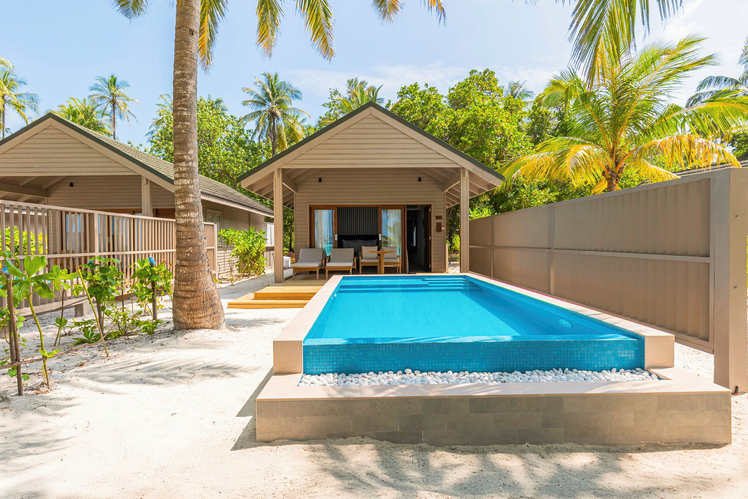 En bungalow med privat pool och omgivande palmer. (AI-genererad text)