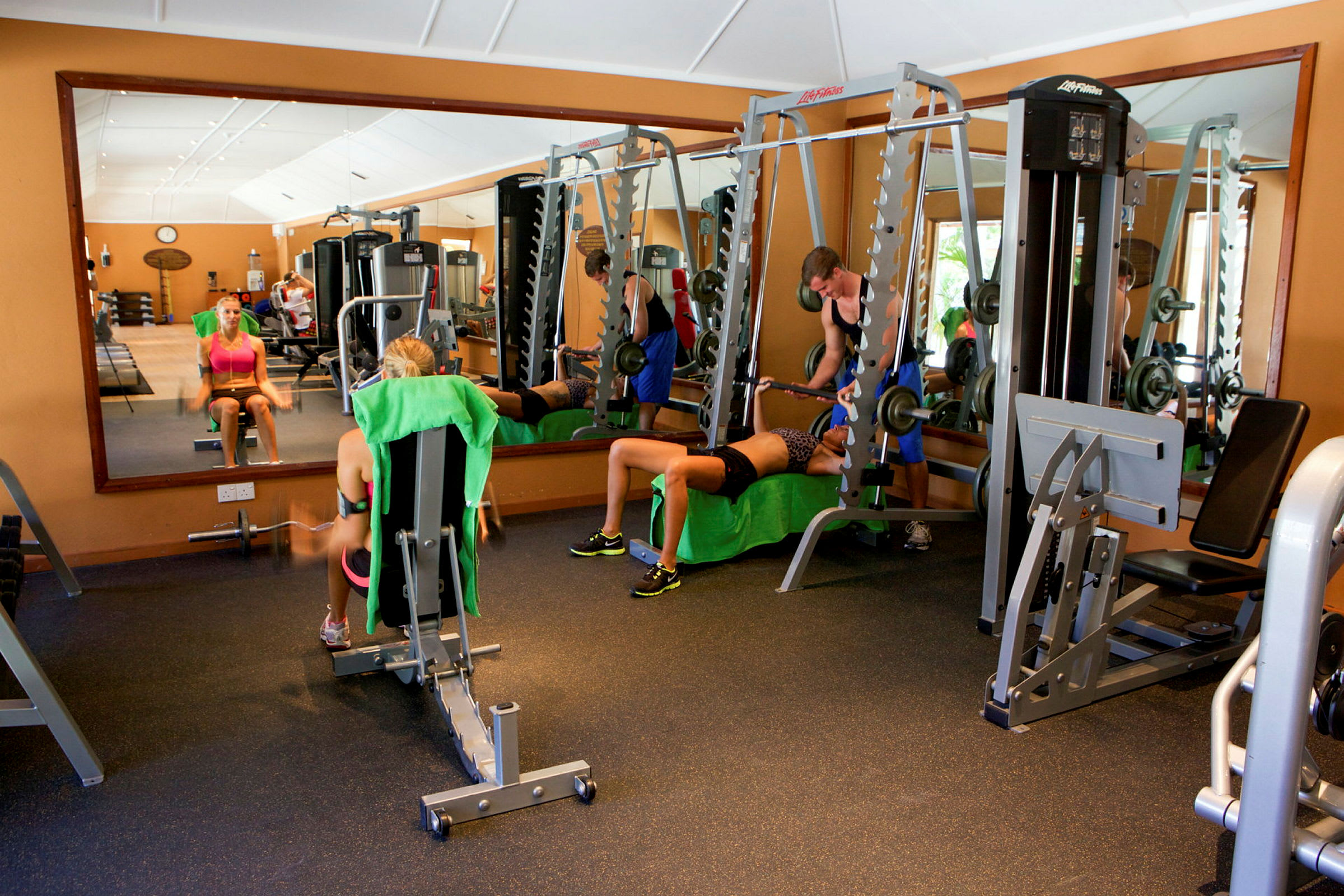 Ett gym med personer som tränar med olika träningsredskap. (AI-genererad text)