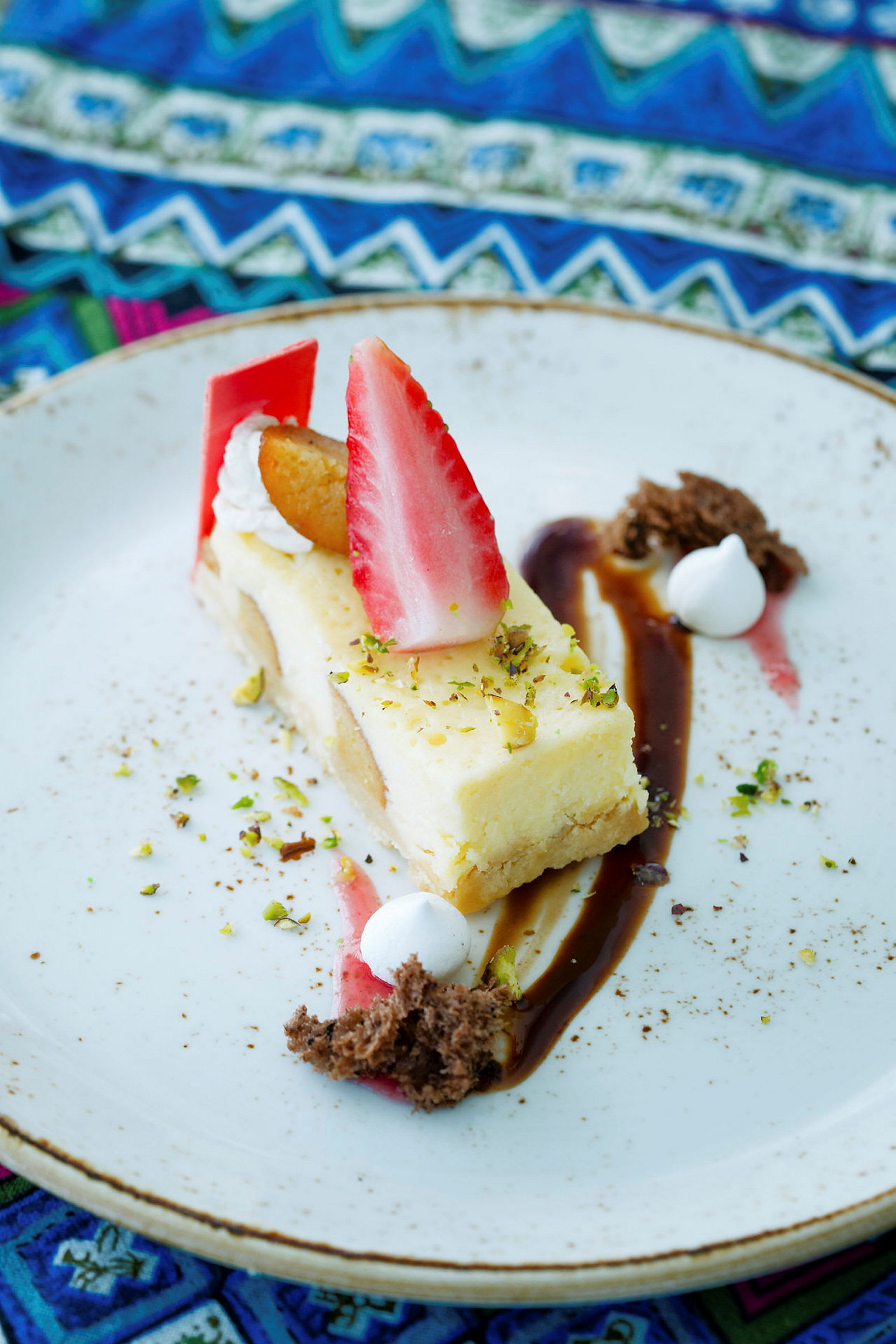 En dessert med cheesecake, jordgubbar och dekorationer på en tallrik. (AI-genererad text)